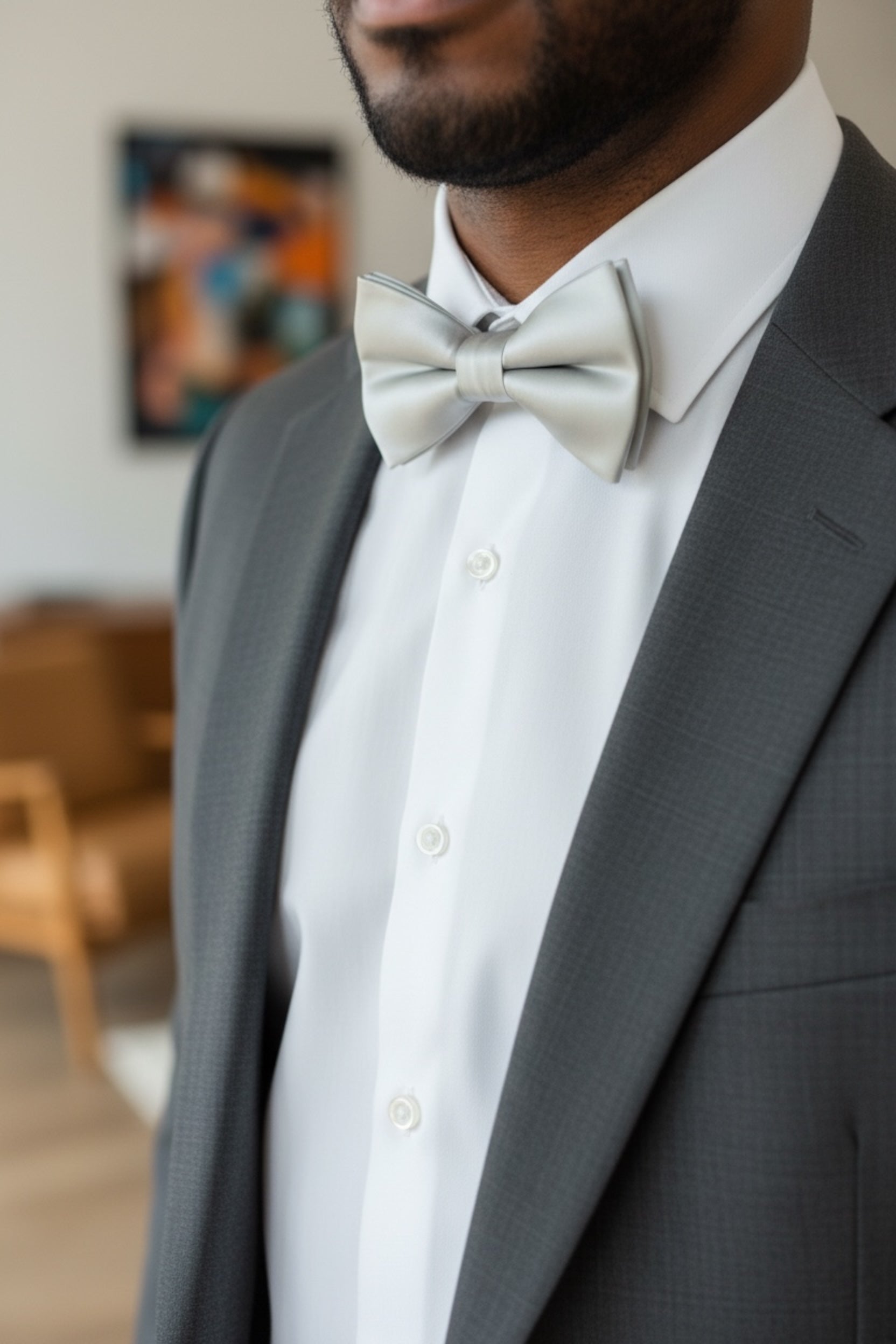 Groomsman wearing a silver bow tie at a wedding.