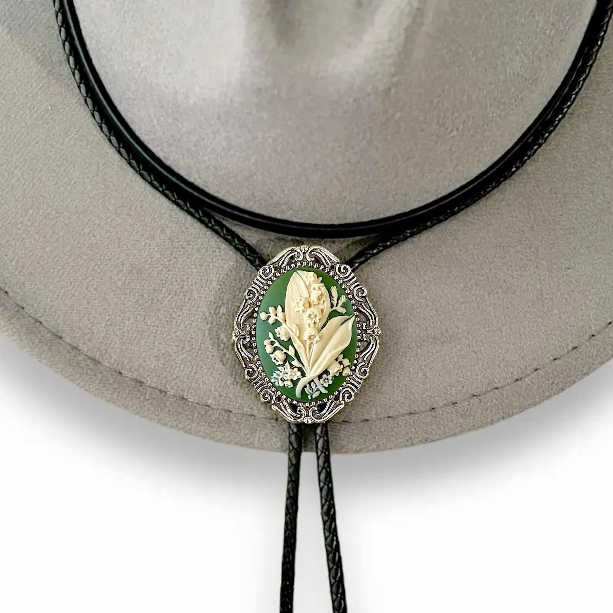 Bolo tie with green lily of the valley may flower design on a hat