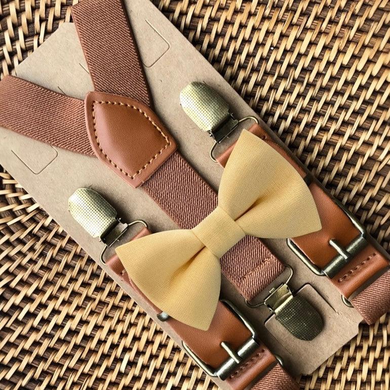 Light yellow bow tie with brown suspenders on a woven surface