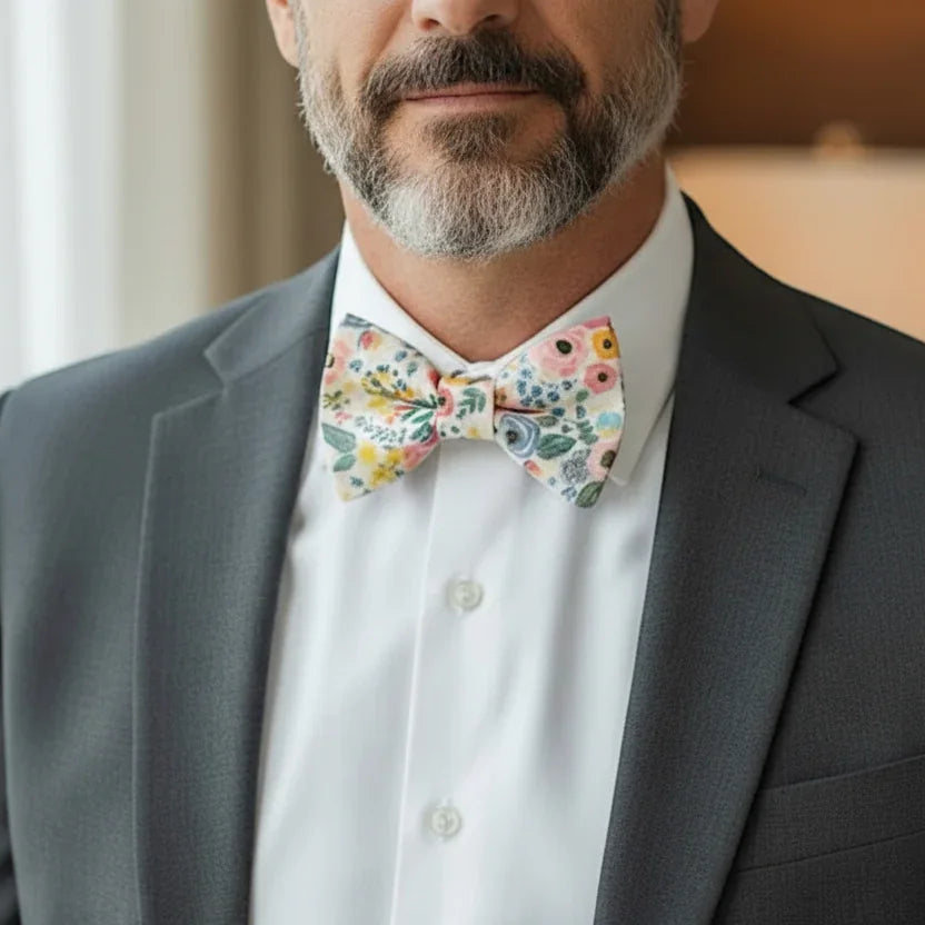 Groomsman in a gray suit with floral bow tie.