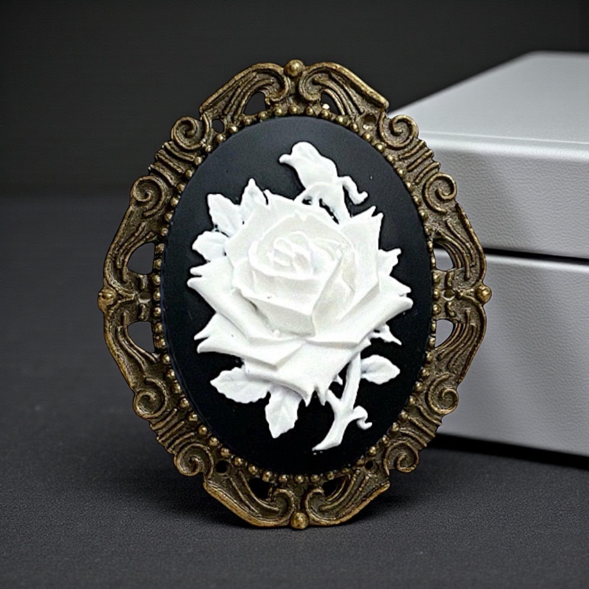 Decorative brooch with white rose design on black background for wedding or gothic accessories.