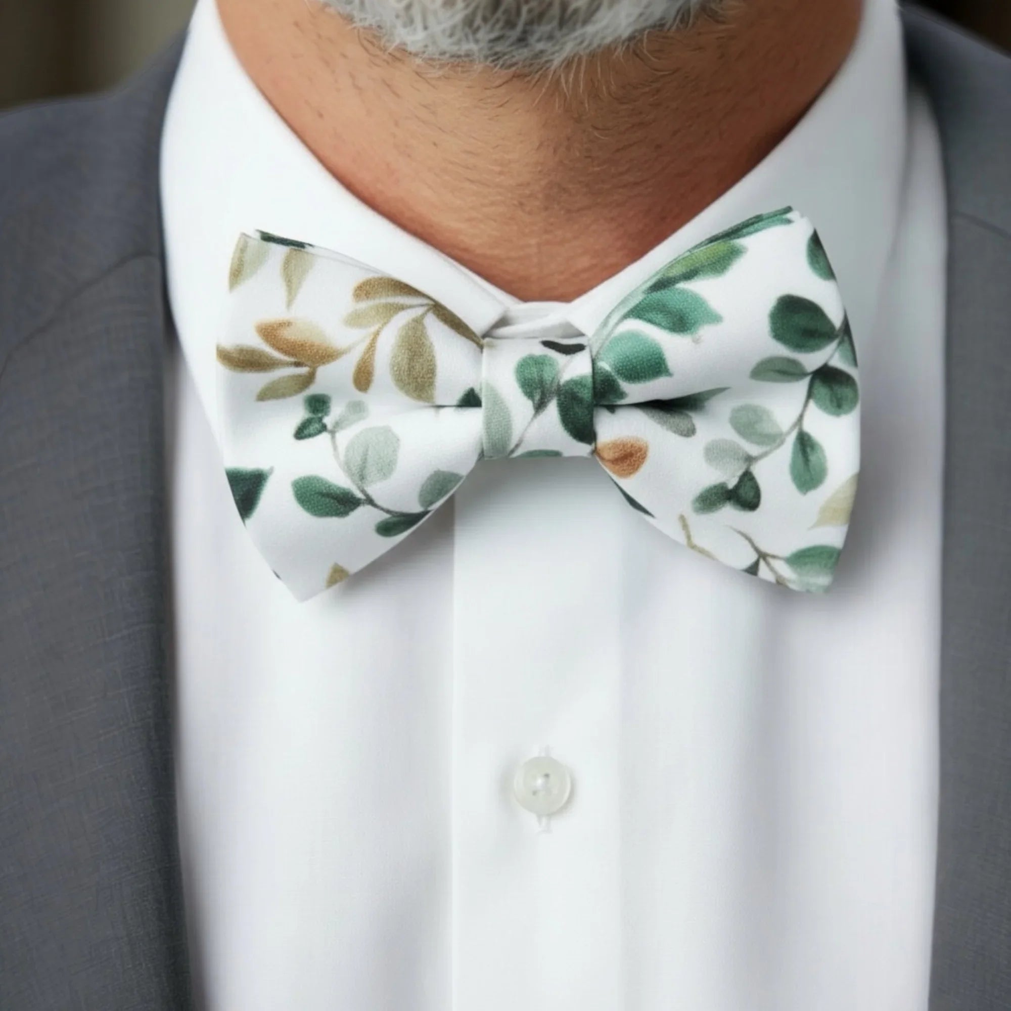 Green floral bow tie for men worn by a groomsman in a suit at a wedding.
