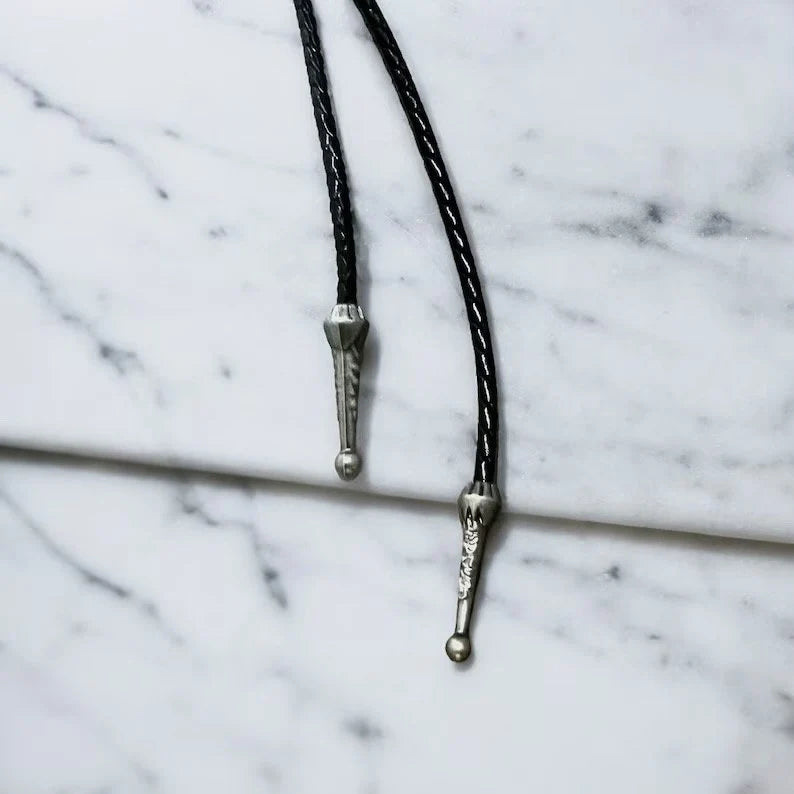 Silver bolo tassels on a black leather cord