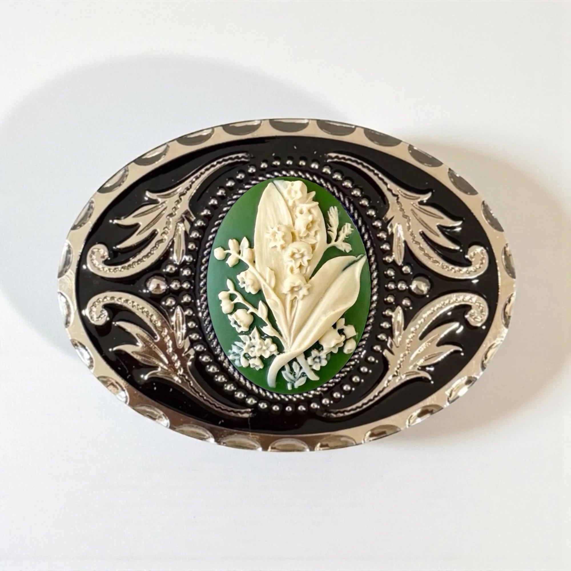 Decorative May flower green lily of the valley belt buckle with floral design on a white background