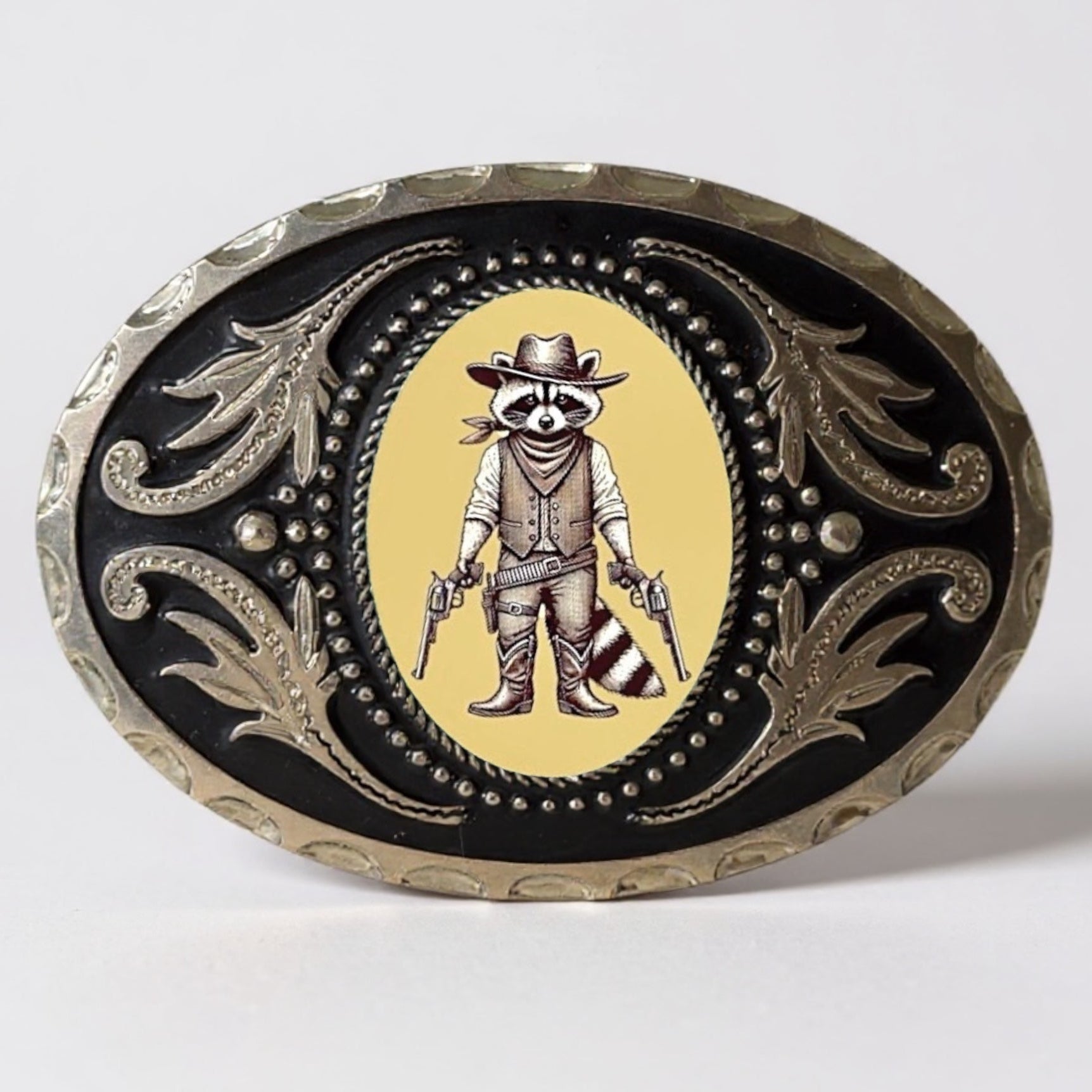 Decorative raccoon belt buckle with guns in cowboy attire on a yellow background