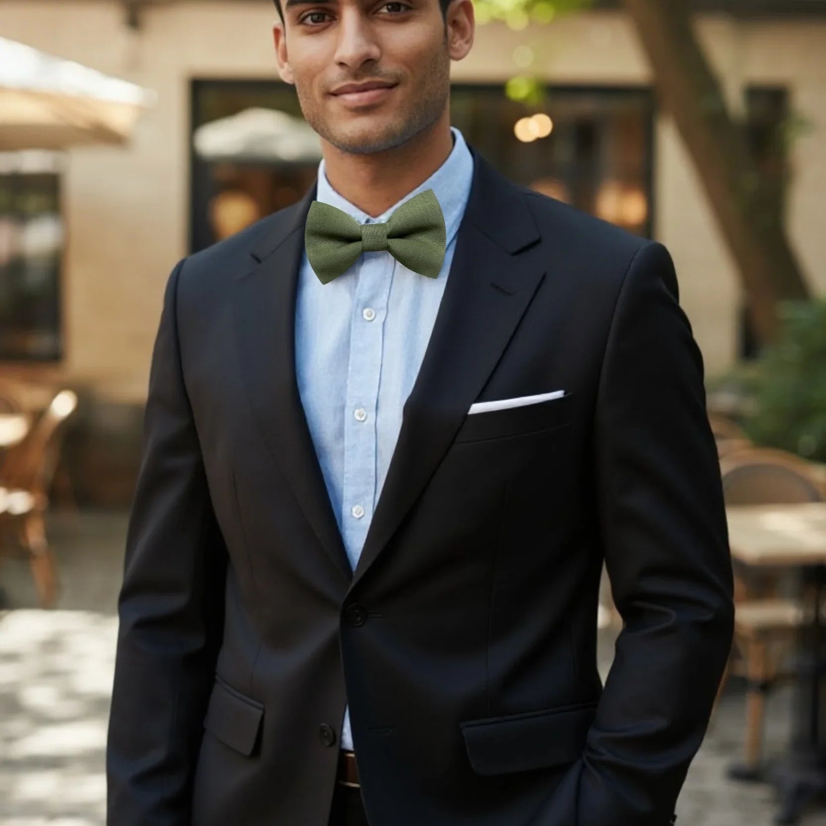 Olive bow tie for men worn by a man in a suit.