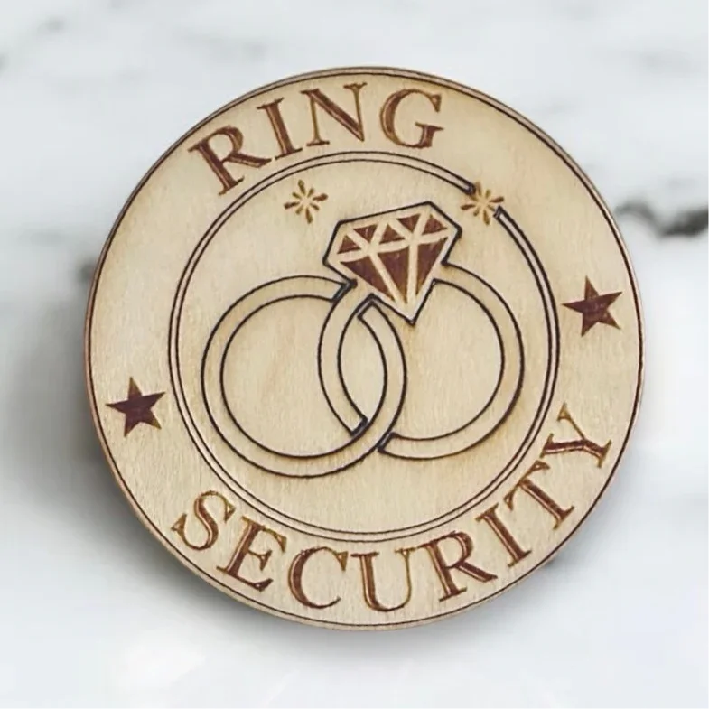 Wooden 'Ring Security' ring bearer badge for a wedding with ring and diamond design on a marble background