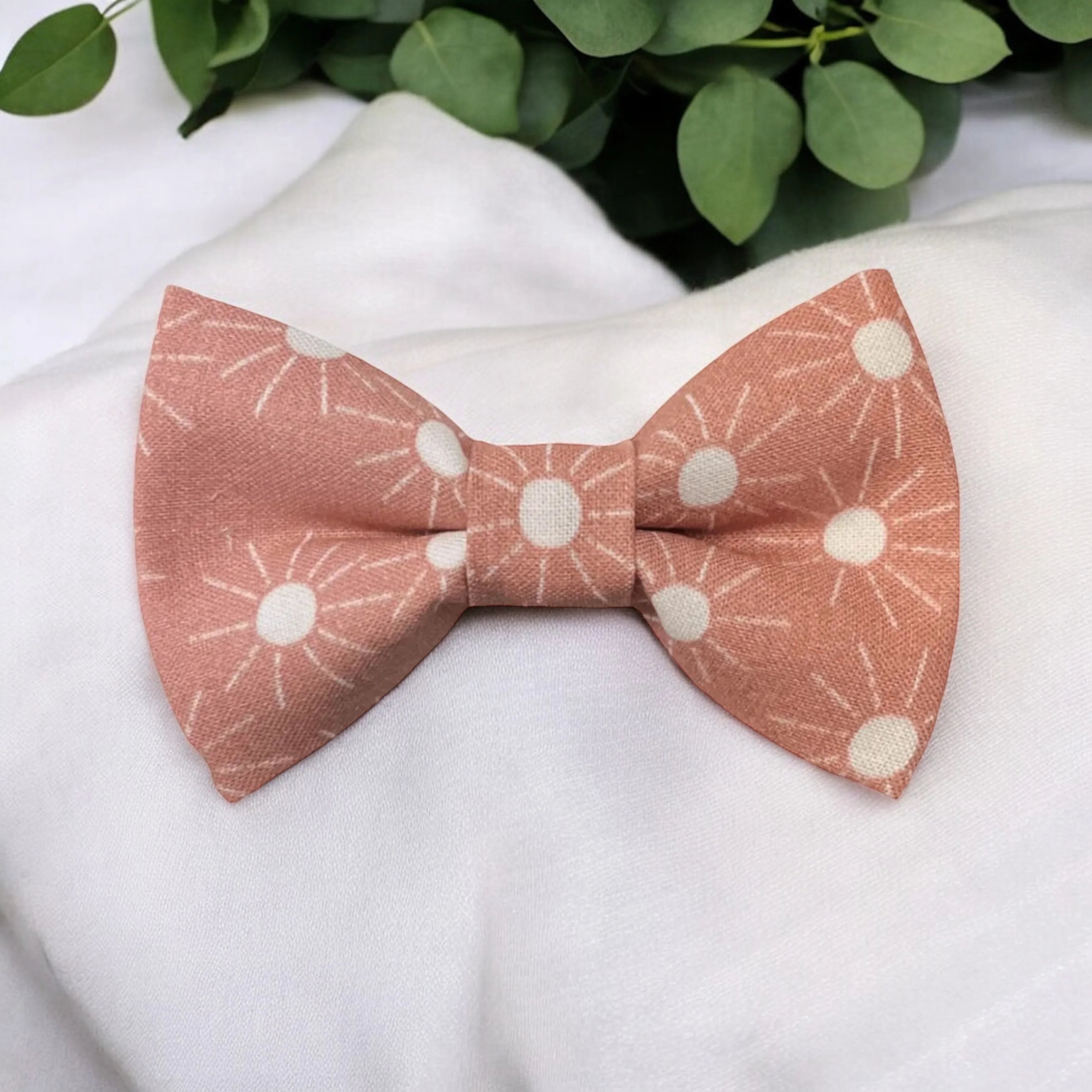 Size chart for pre-tied bow ties from The Bold Bow Tie detailing measurements across three sizes. Small is 3.5 inches wide and recommended for ages 6 months to 5 years. Medium is 4 inches wide and recommended for ages 6 to 12 years. Large is 4.5 inches wide and recommended for ages 13 years and up. Visual icons illustrate the relative sizes with horizontal arrows showing that width is measured from wingtip to wingtip. Bottom text notes that all bow ties are pre-tied and ready to add to your outfit.