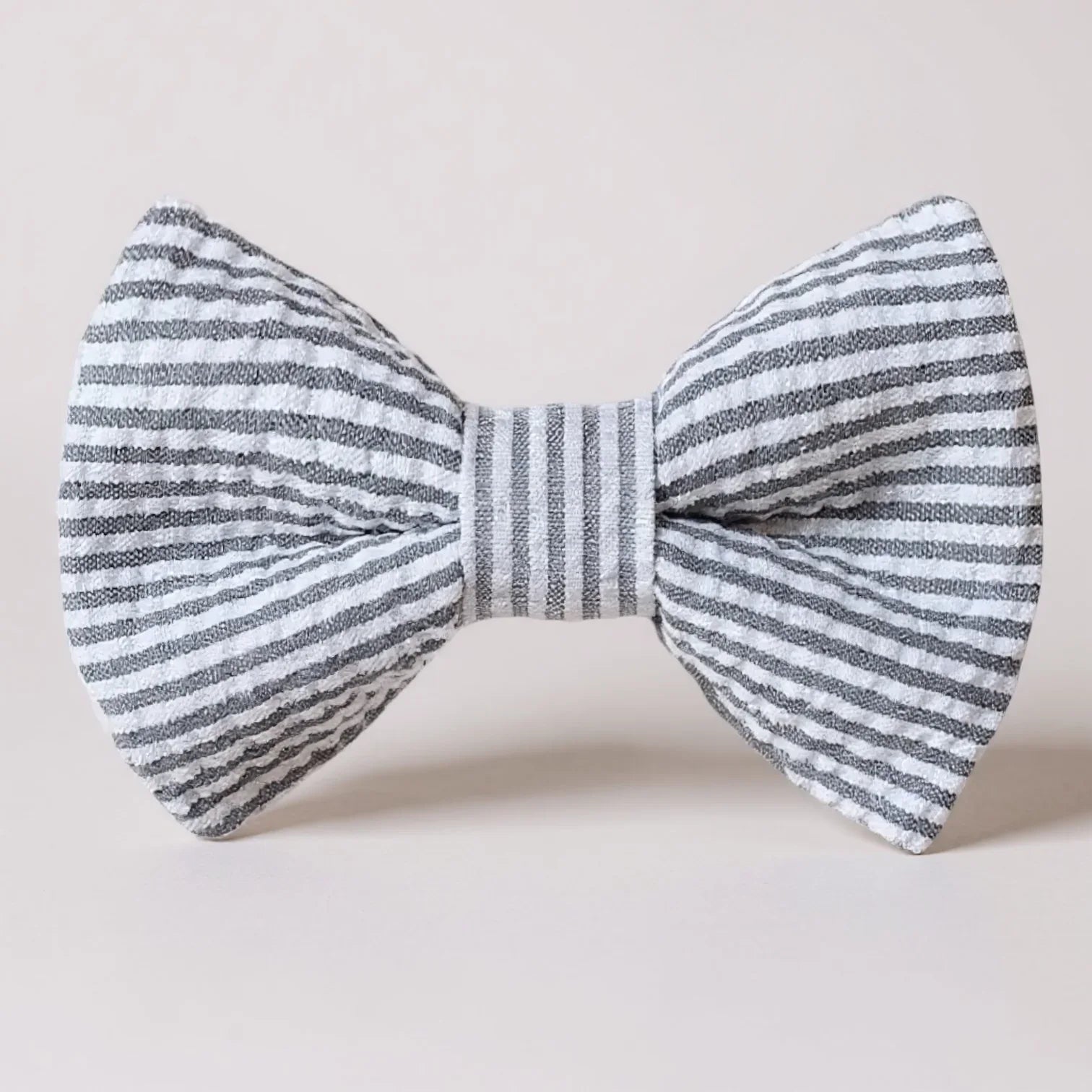 Striped gray seersucker bow tie on a light gray background for Easter