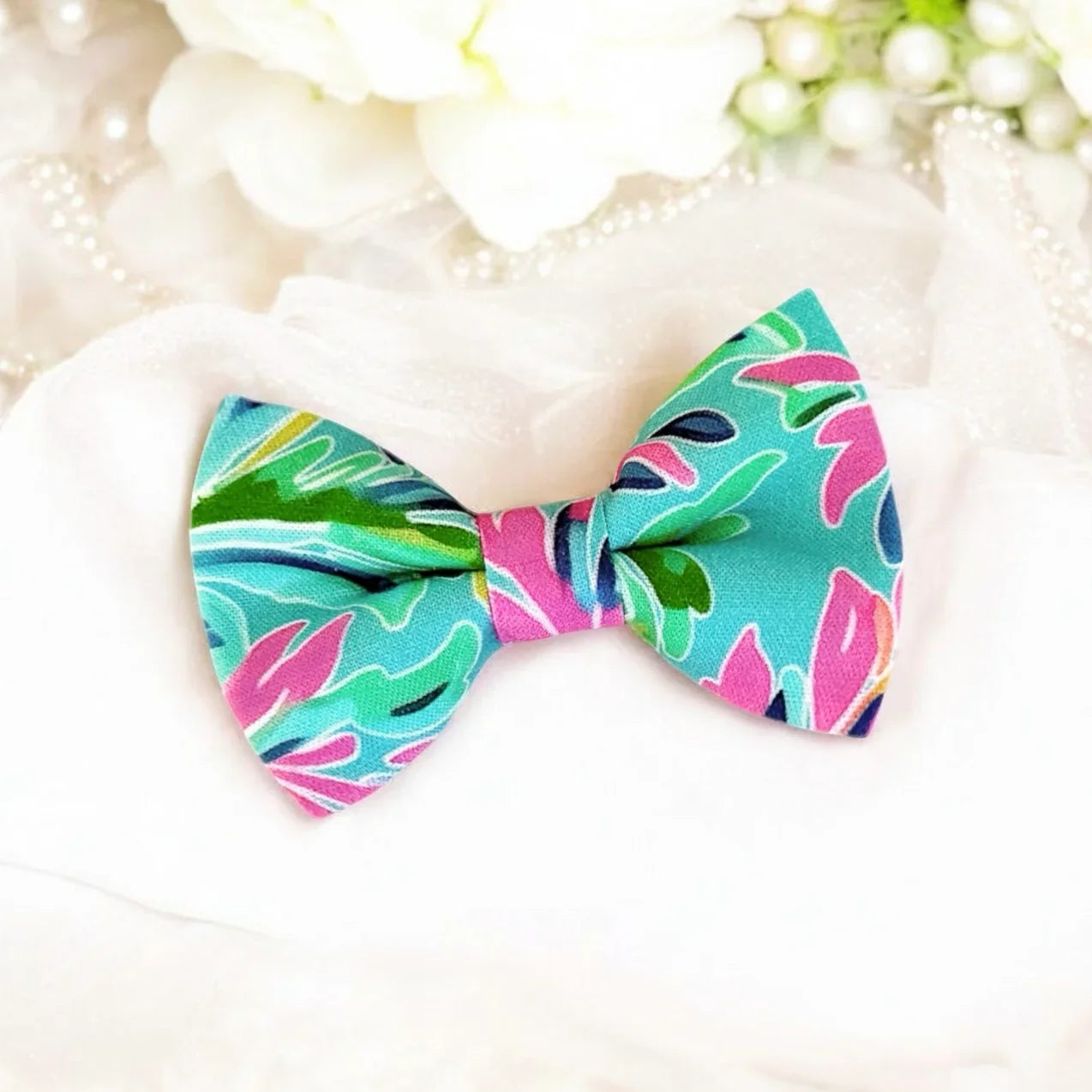 Size chart for pre-tied bow ties from The Bold Bow Tie detailing measurements across three sizes. Small is 3.5 inches wide and recommended for ages 6 months to 5 years. Medium is 4 inches wide and recommended for ages 6 to 12 years. Large is 4.5 inches wide and recommended for ages 13 years and up. Visual icons illustrate the relative sizes with horizontal arrows showing that width is measured from wingtip to wingtip. Bottom text notes that all bow ties are pre-tied and ready to add to your outfit.