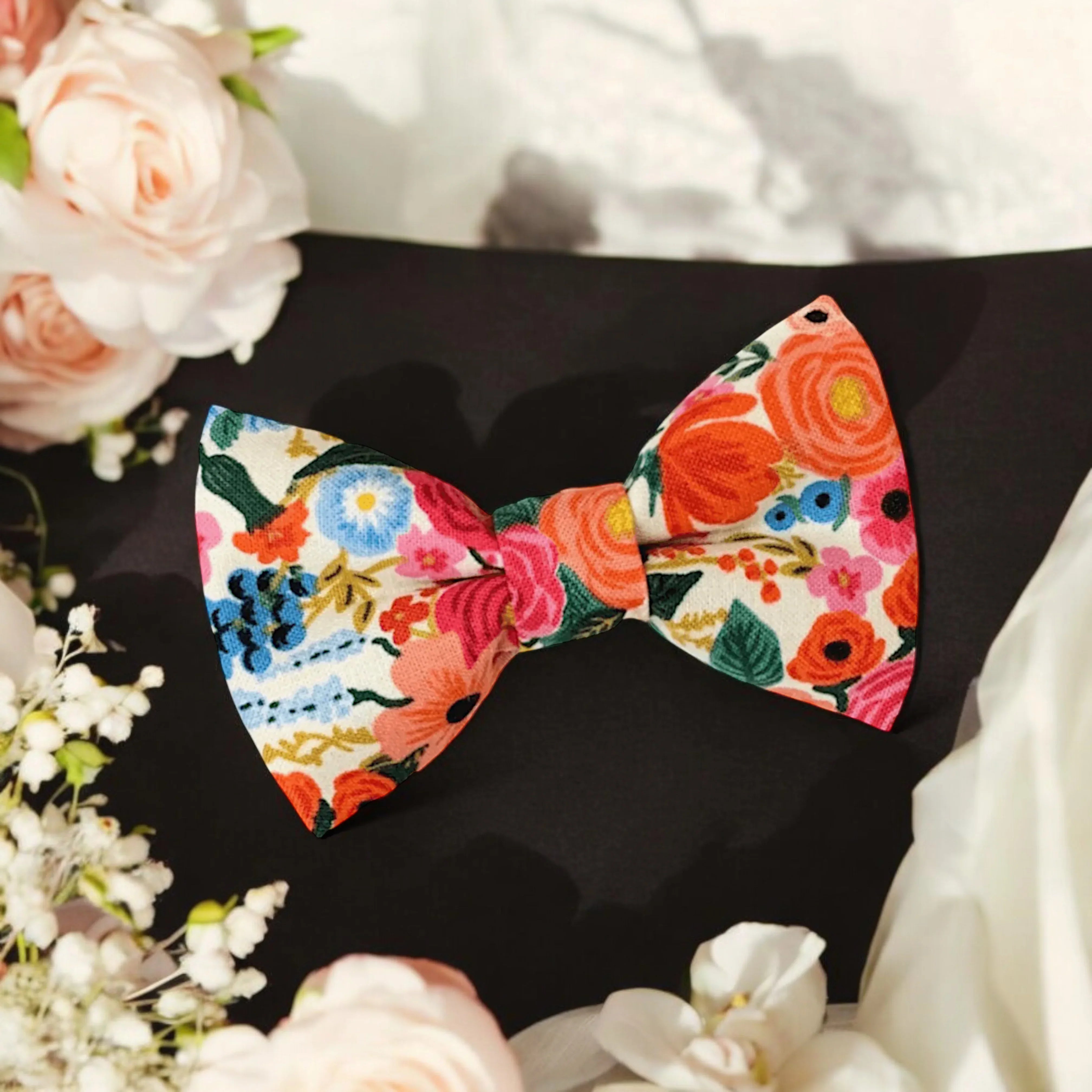 Size chart for pre-tied bow ties from The Bold Bow Tie detailing measurements across three sizes. Small is 3.5 inches wide and recommended for ages 6 months to 5 years. Medium is 4 inches wide and recommended for ages 6 to 12 years. Large is 4.5 inches wide and recommended for ages 13 years and up. Visual icons illustrate the relative sizes with horizontal arrows showing that width is measured from wingtip to wingtip. Bottom text notes that all bow ties are pre-tied and ready to add to your outfit.