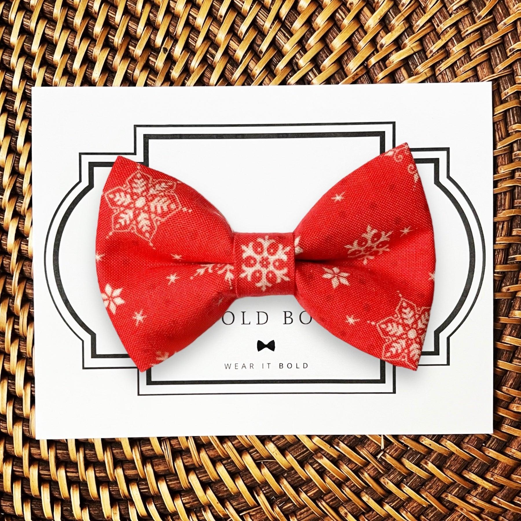 Red snowflake bow tie for dog collar and cat collar presented on a white card with a decorative black border