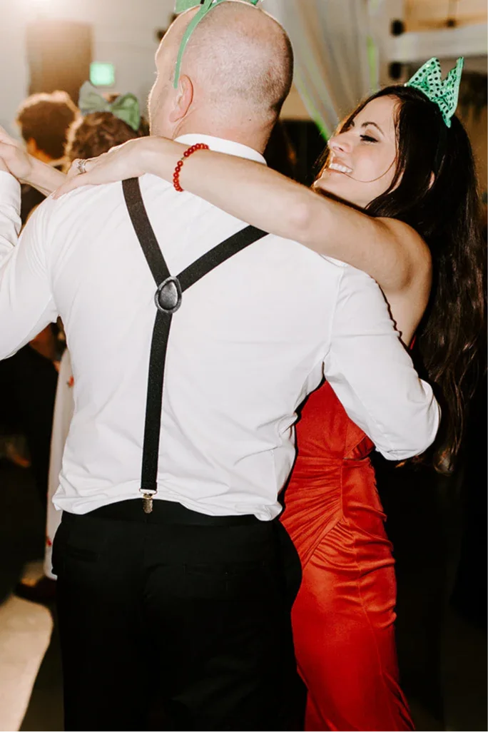 Man dancing with a woman at a wedding in black suspenders, Y-back.