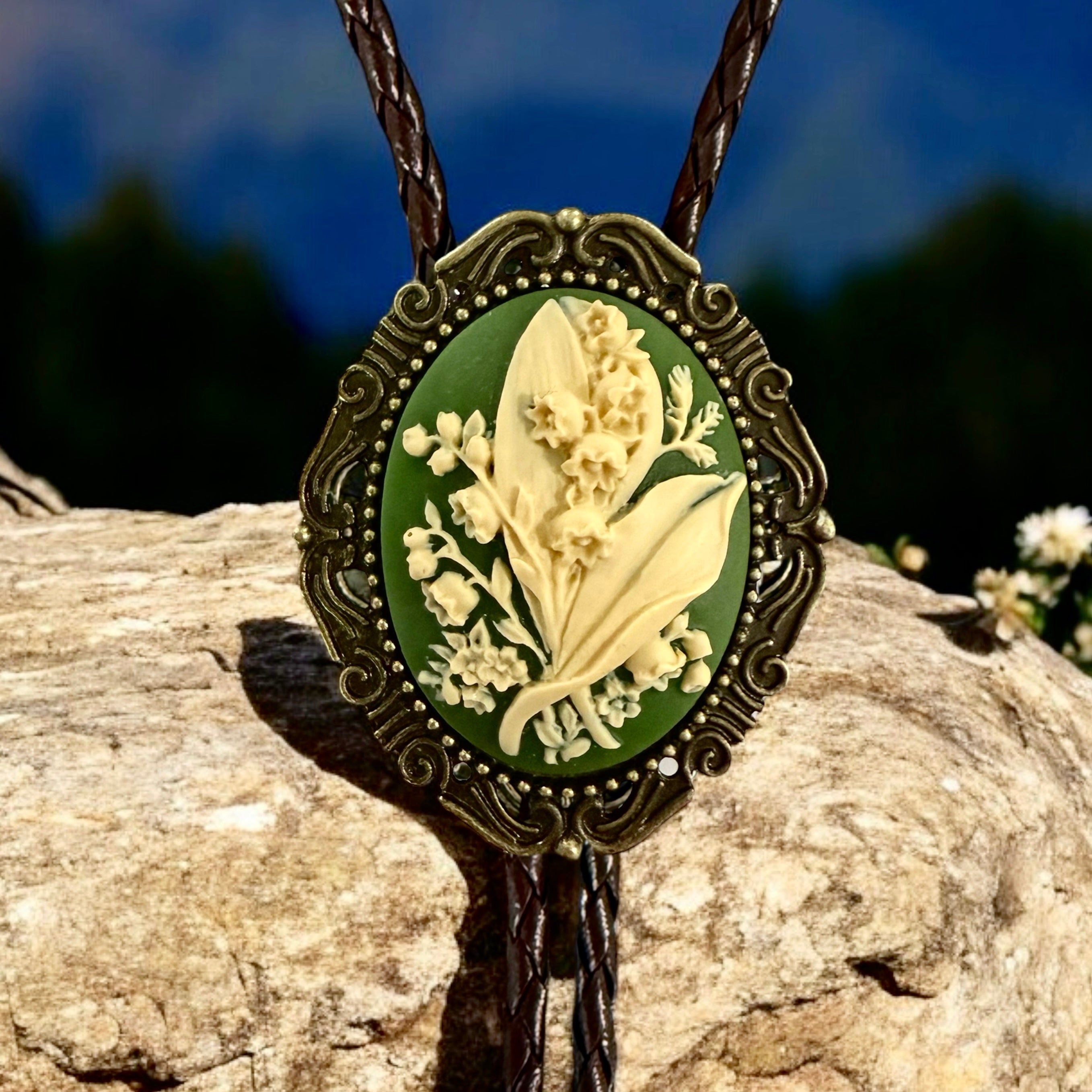Decorative bolo tie with floral design on a rock