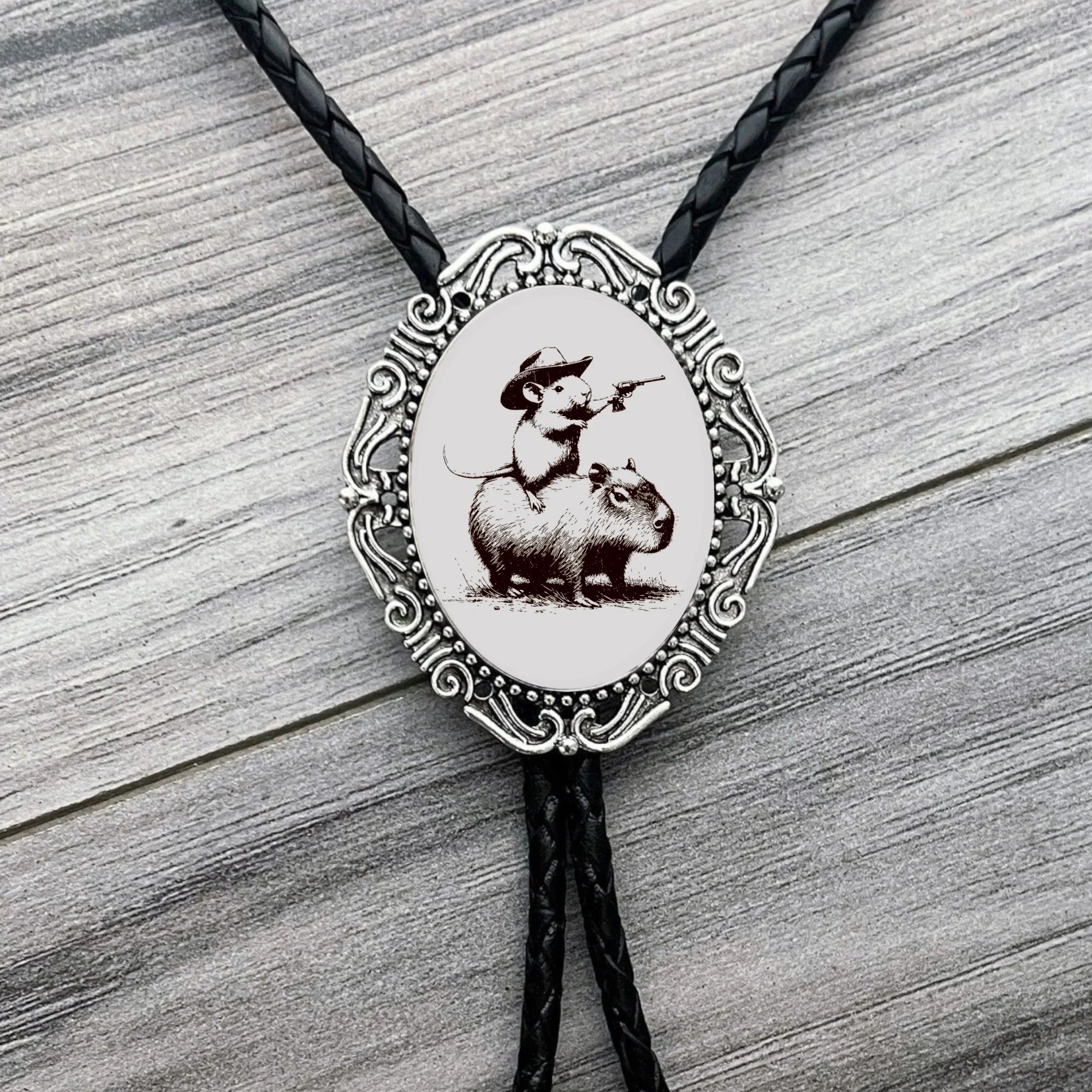 Silver back of a bolo tie with a clamp on a black leather cord