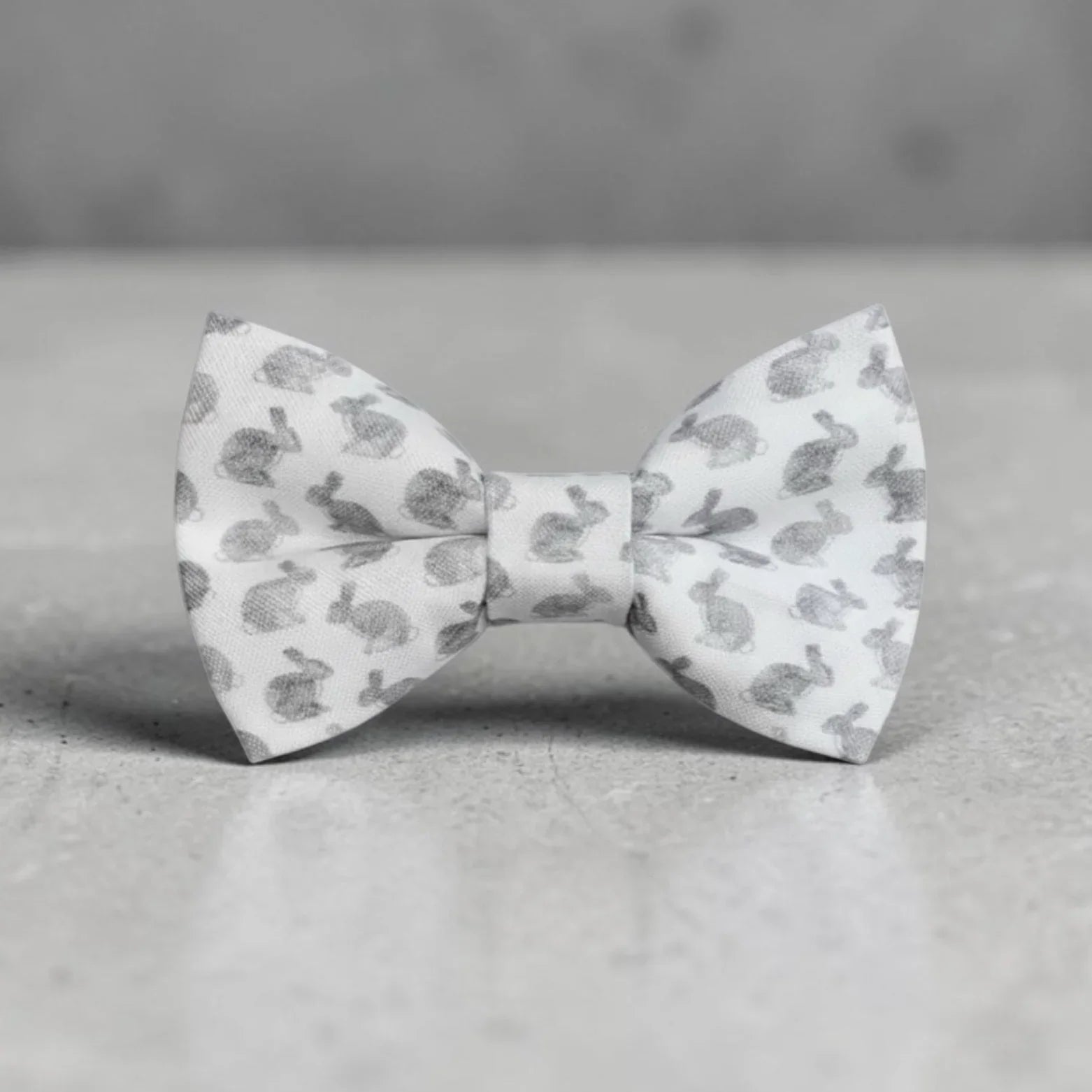 Size chart for pre-tied bow ties from The Bold Bow Tie detailing measurements across three sizes. Small is 3.5 inches wide and recommended for ages 6 months to 5 years. Medium is 4 inches wide and recommended for ages 6 to 12 years. Large is 4.5 inches wide and recommended for ages 13 years and up. Visual icons illustrate the relative sizes with horizontal arrows showing that width is measured from wingtip to wingtip. Bottom text notes that all bow ties are pre-tied and ready to add to your outfit.