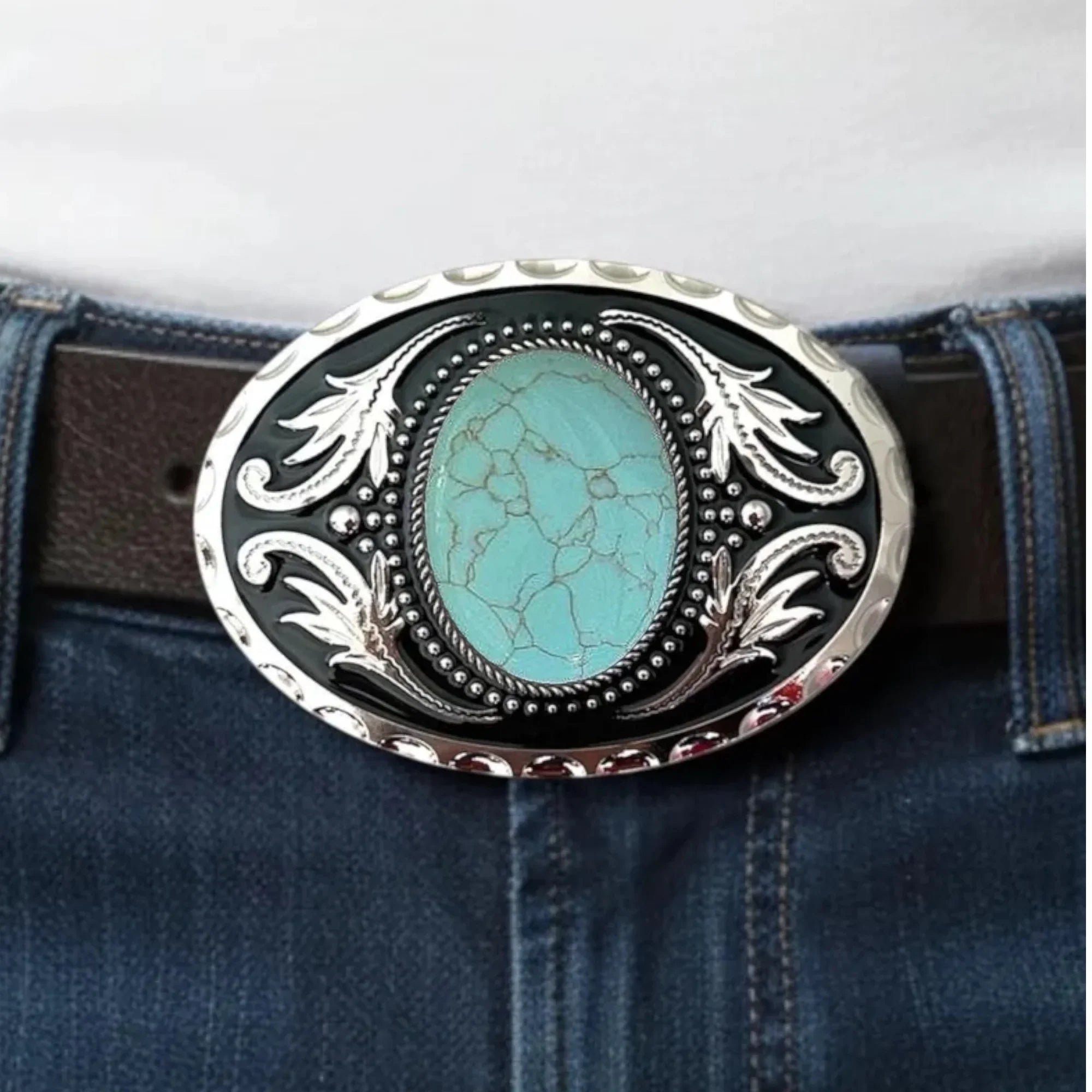 Turquoise stone belt buckle on a belt with jeans in the background