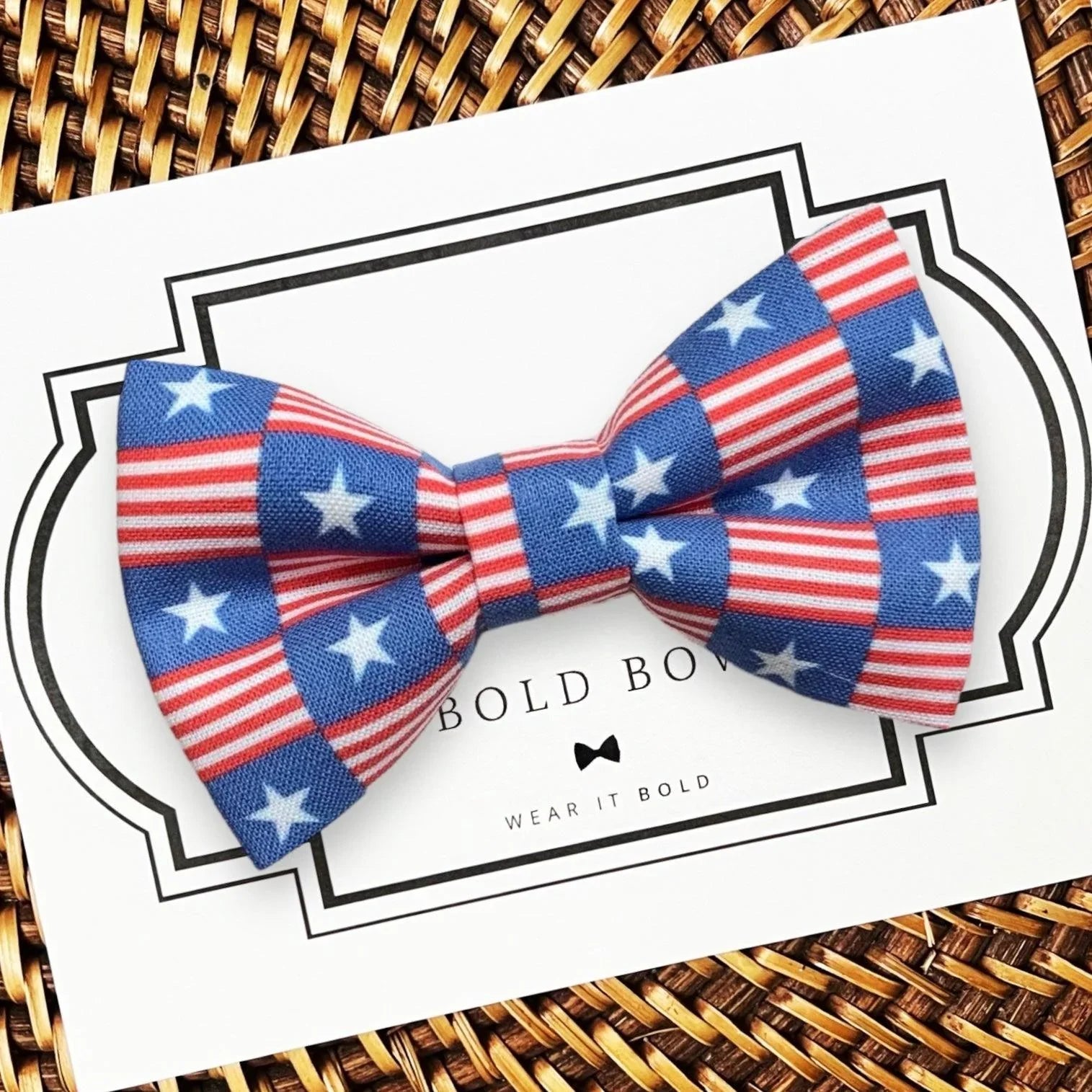 Dog bow tie with American flag pattern on a card with 'TheBold Bowtie’ branding.