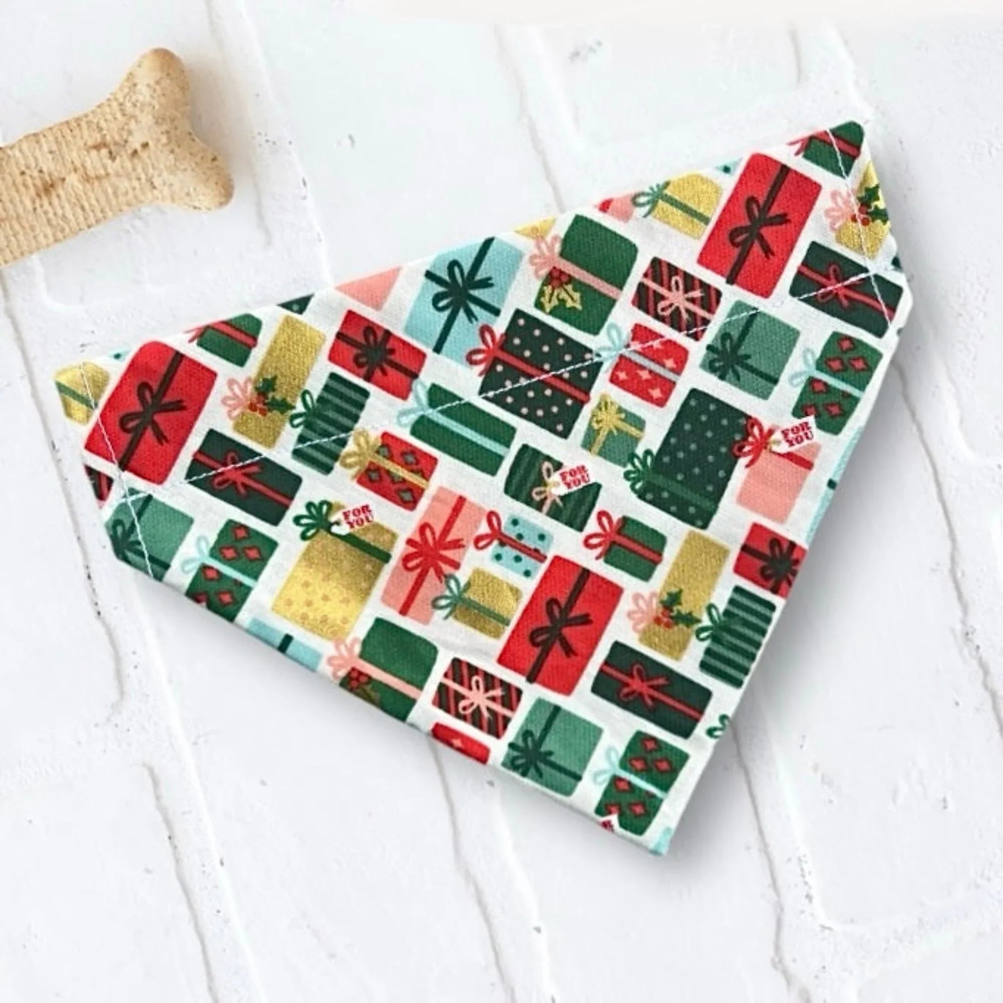 Festive dog bandana with colorful gift box pattern in red green and gold on white background
