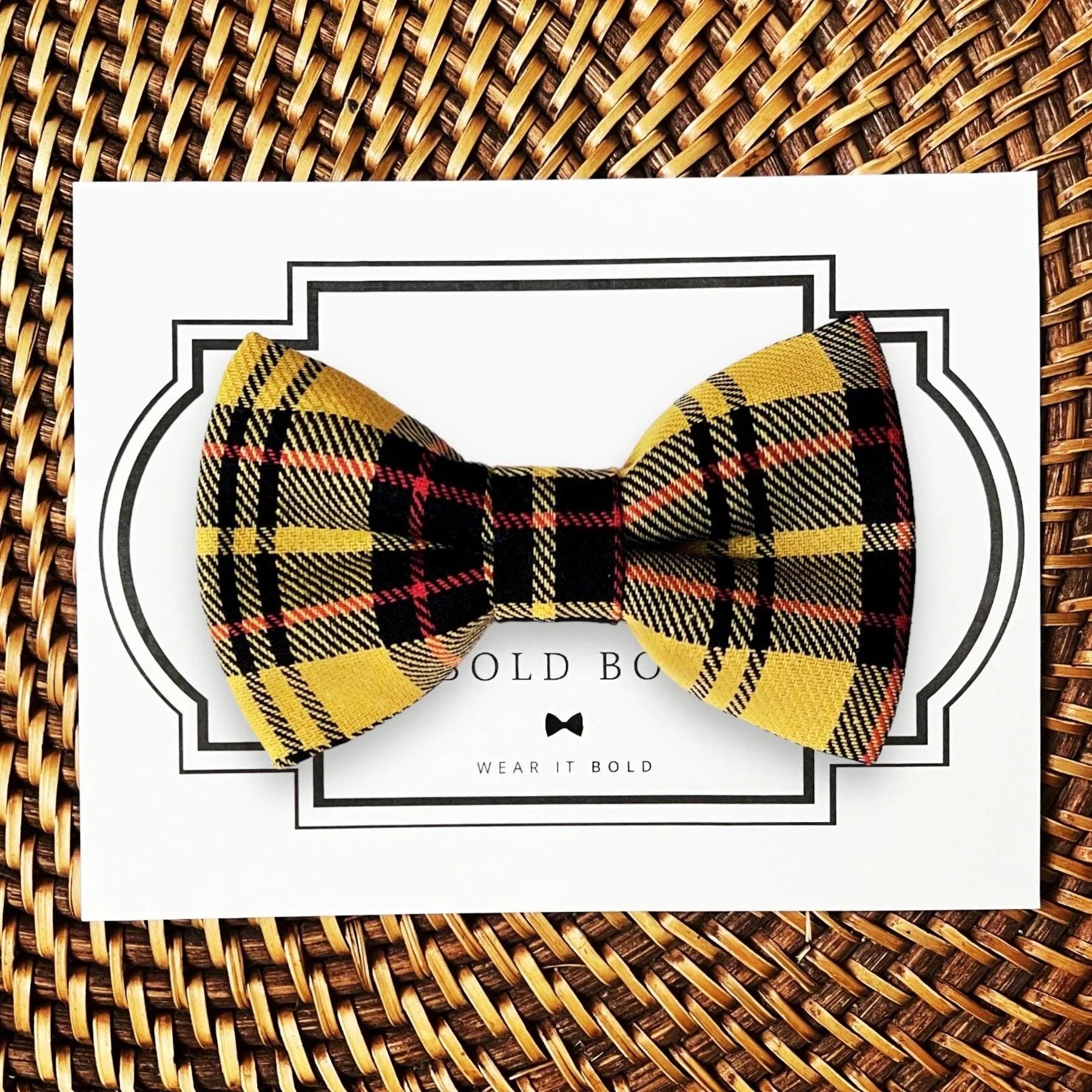 Mustard yellow and black plaid bow tie for dog or cat collar displayed on a white card with a decorative border