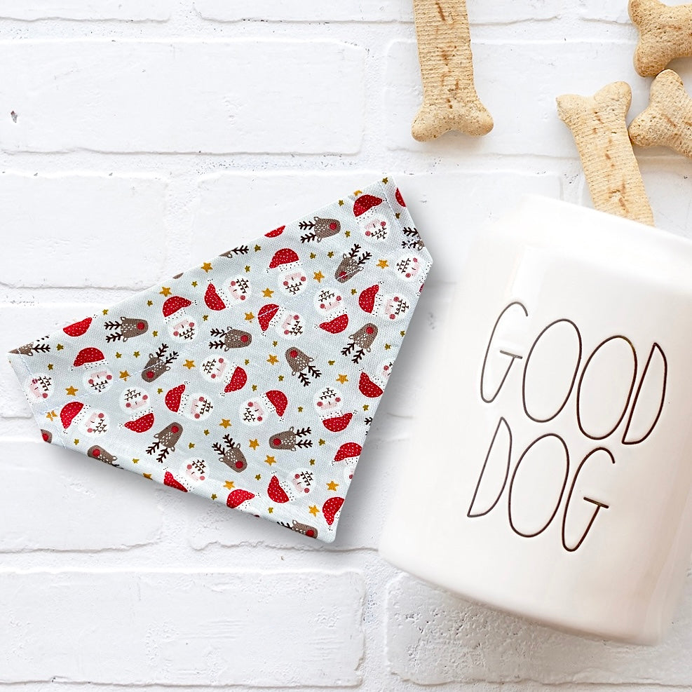 Christmas Dog bandana with festive pattern and 'GOOD DOG' mug on a white wooden surface