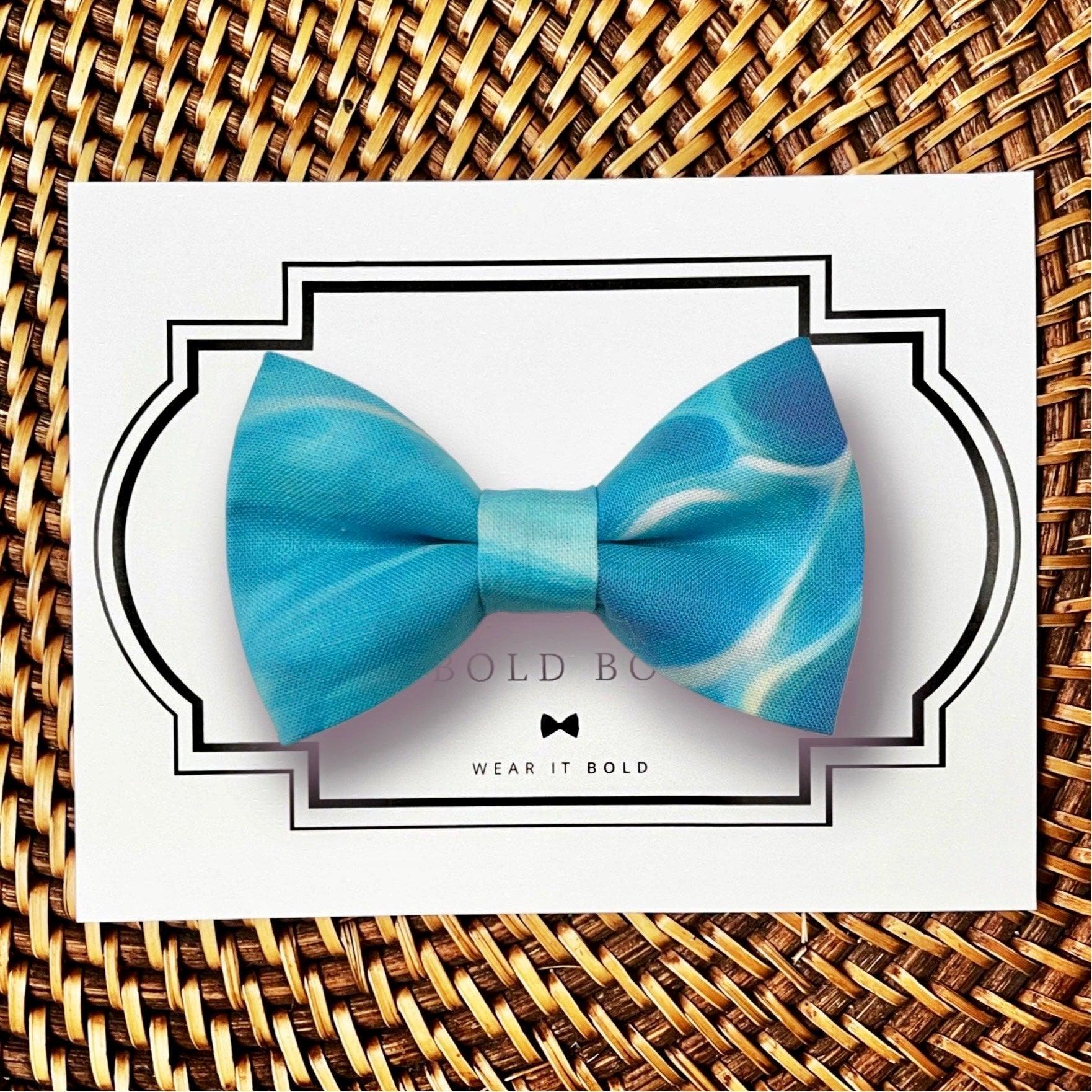 Blue wave patterned bow tie on white card with decorative frame on a woven placemat
