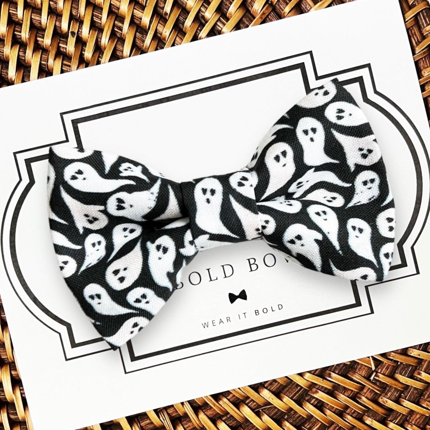 A black and white ghost pattern dog bow tie for pets, displayed on a card with the brand 'The Bold Bow Tie' visible.
