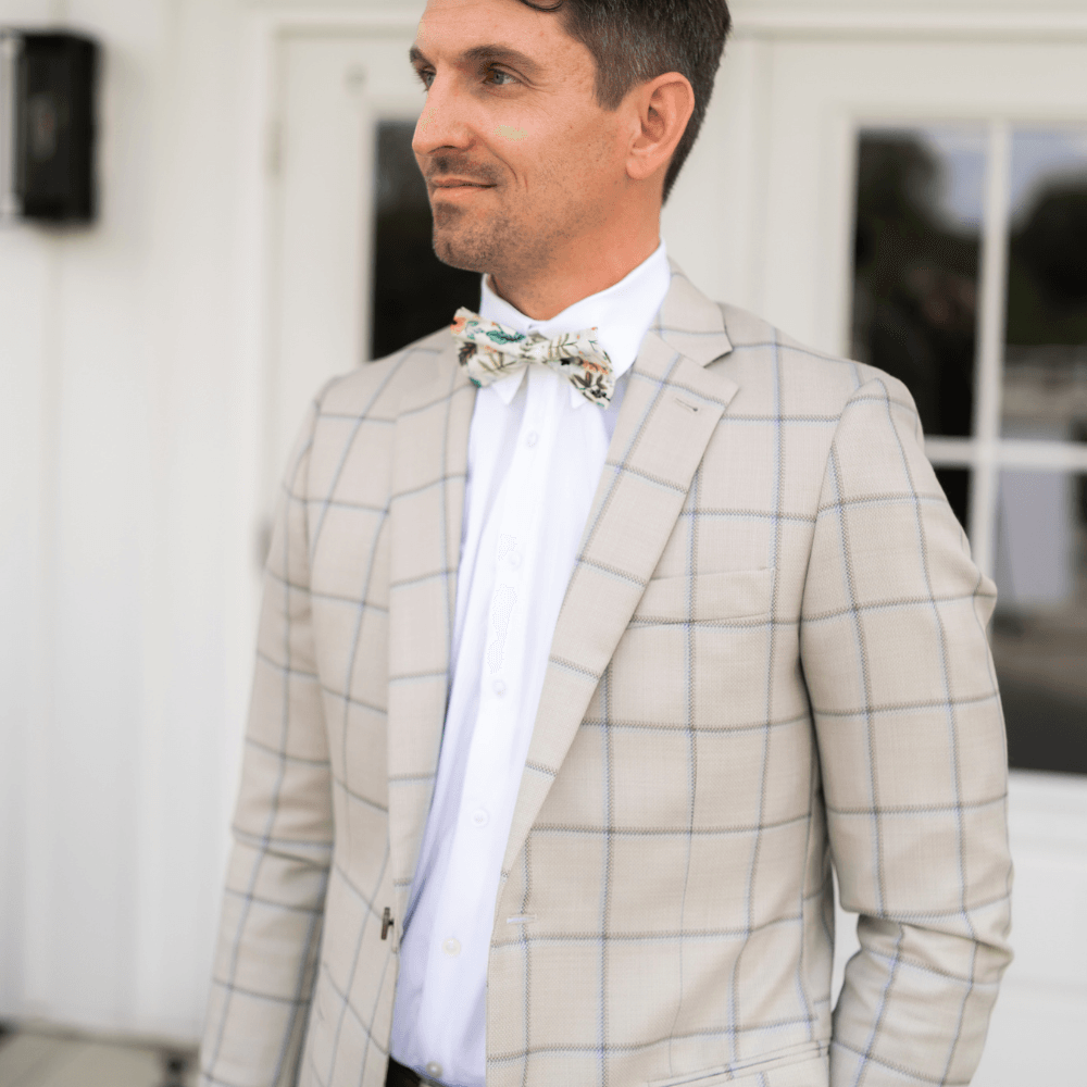 Groom waiting for his bride in an ivory floral bow tie.