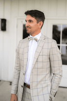 Groom waiting for his bride in an ivory floral bow tie.