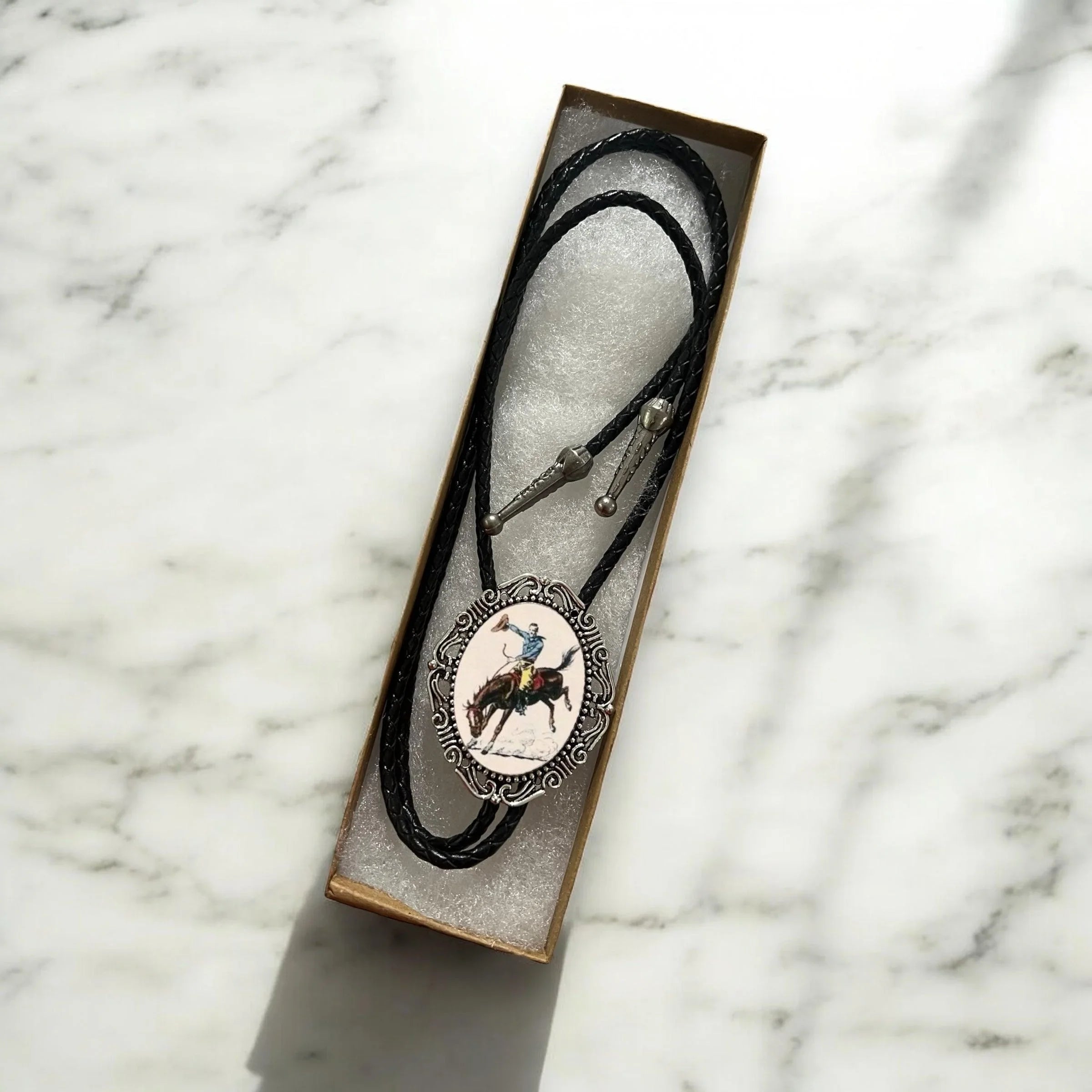 Cowboy bolo tie with black leather cord.
