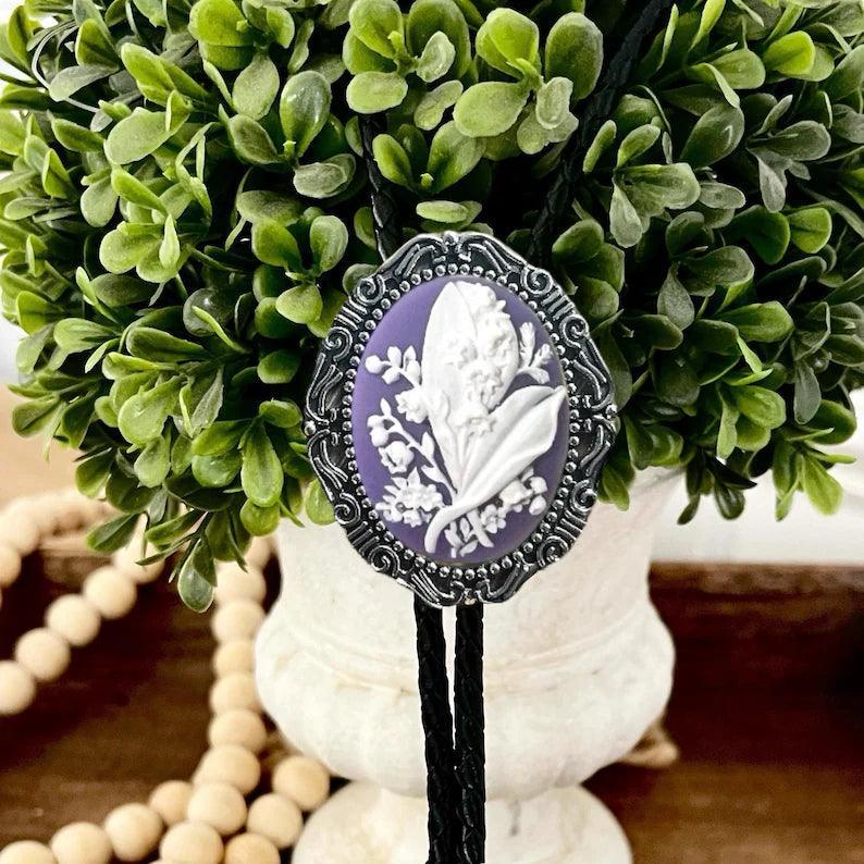 Purple bolo tie with flowers.