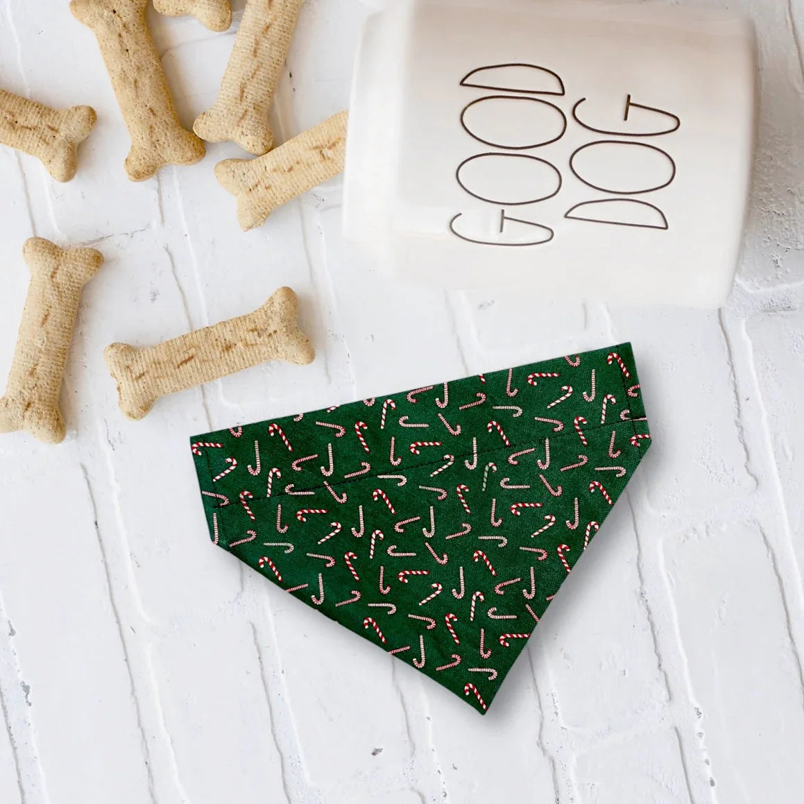 Green candy cane print bandana laid on a white tiled surface