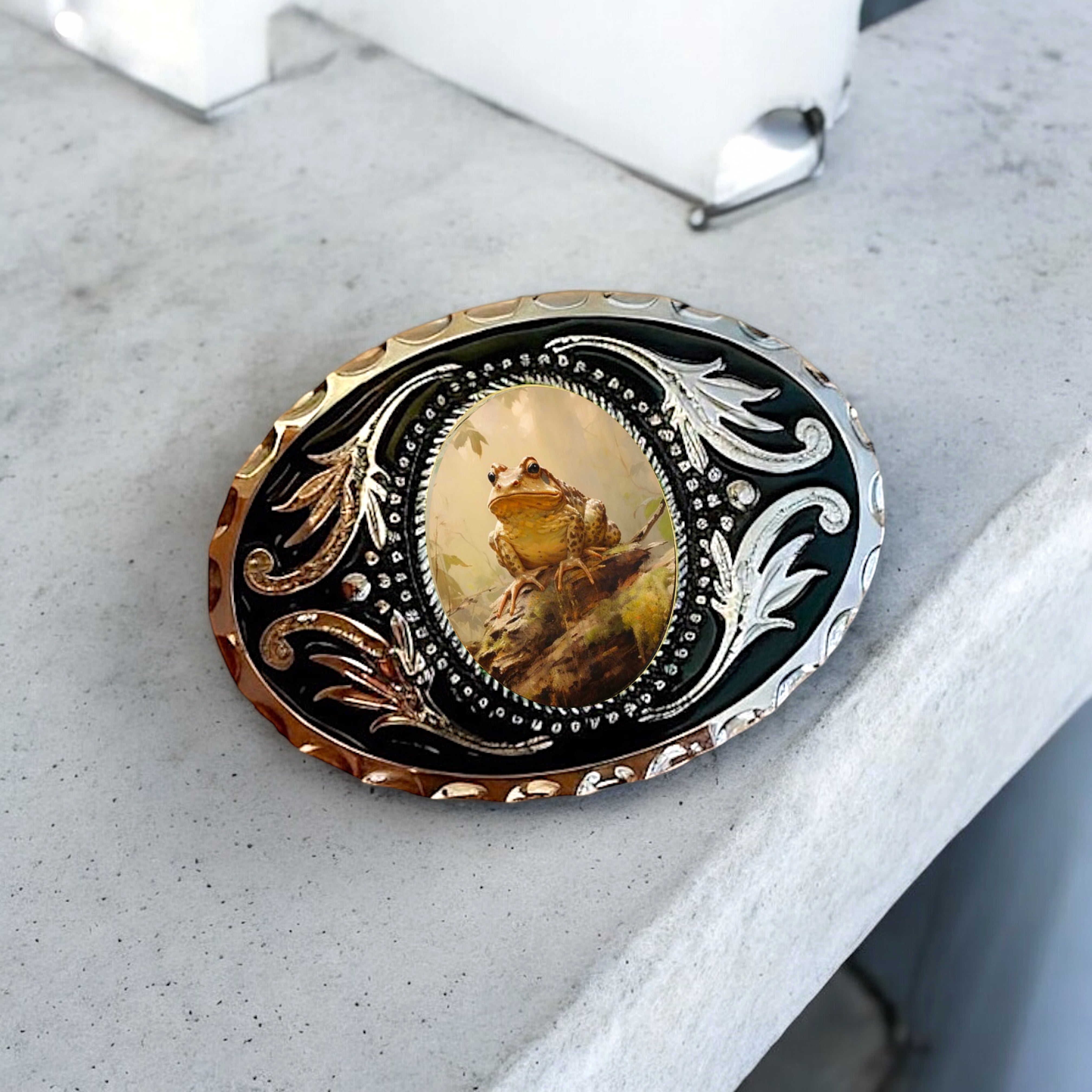 Belt buckle with frog design and intricate metalwork on a white background