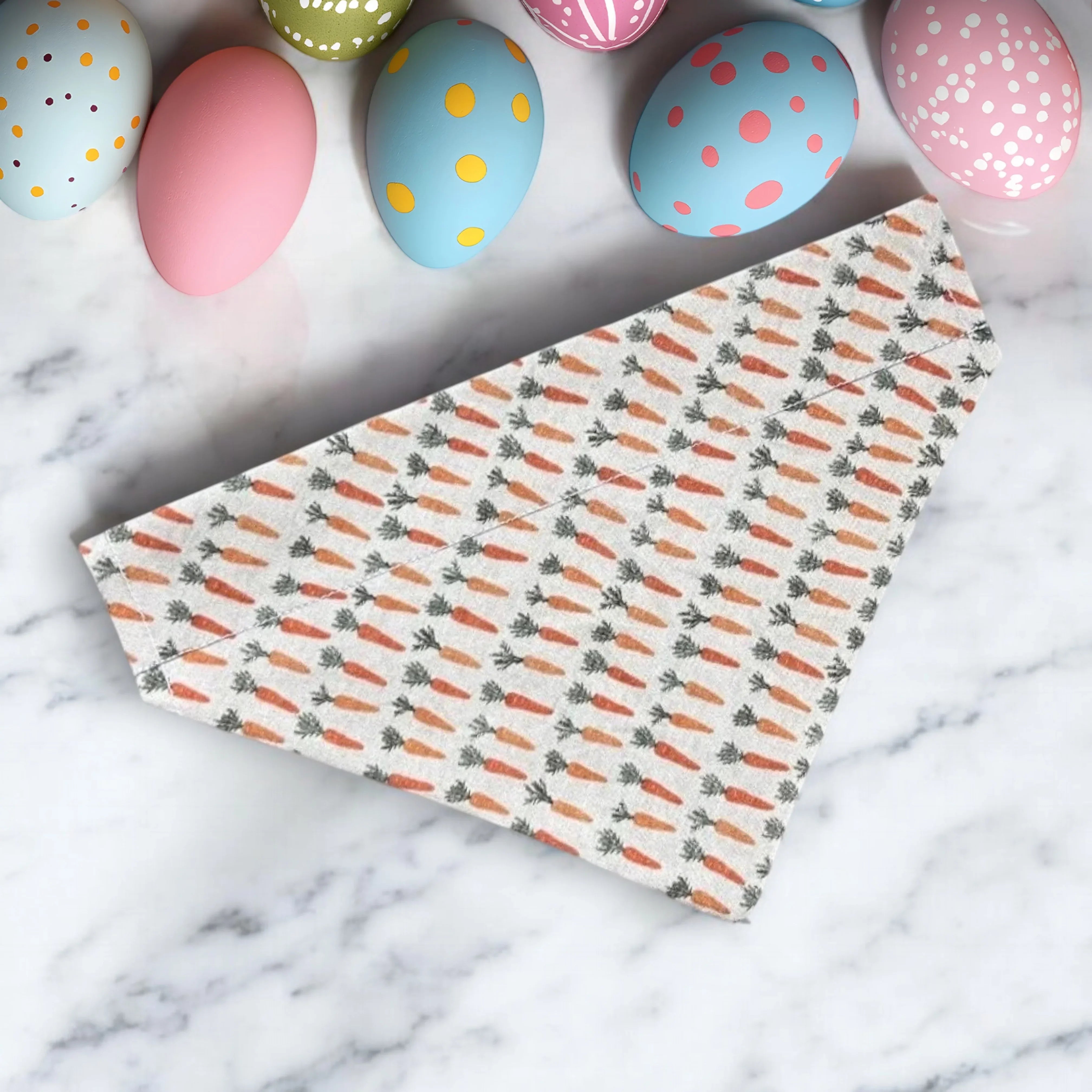 Carrot patterned fabric for a vintage Easter dog or cat bandana with pastel eggs in the background
