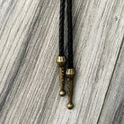 Brass tassels on black leather cord