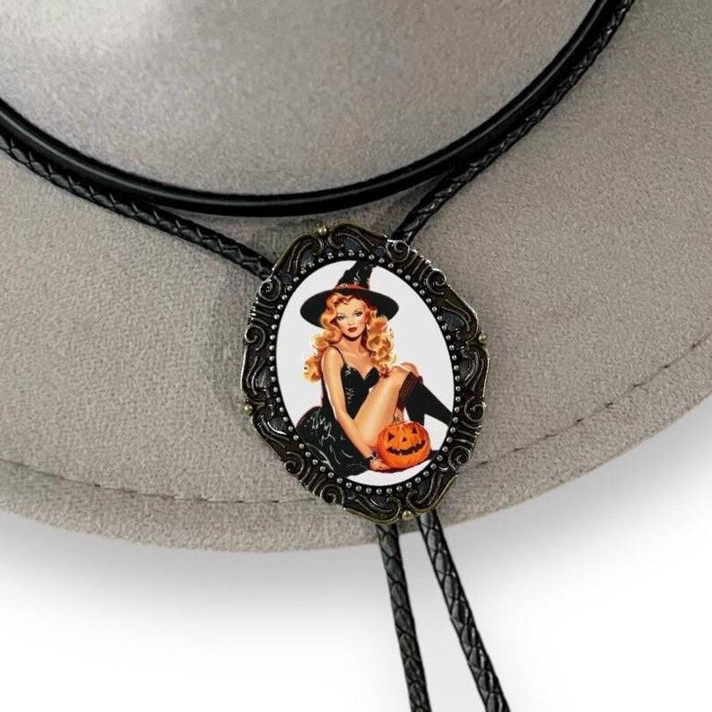 Witchy bolo tie with ornate oval pendant showing a blonde witch holding a jack-o-lantern