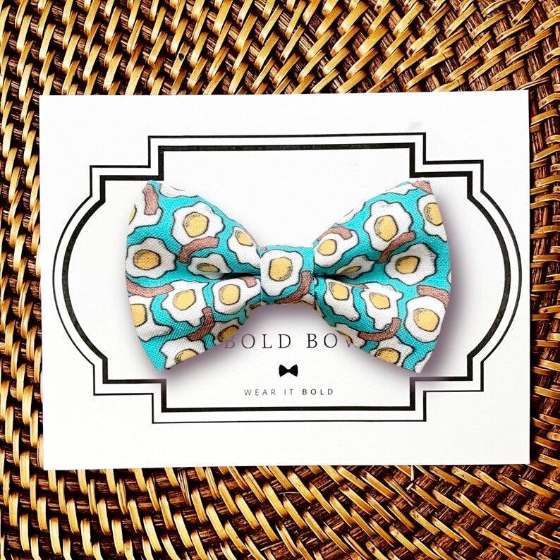 Dog bow tie size chart. Size Small is 3 1/2 inches wide for small dogs under 15 lbs. Size Medium is 4 inches wide for medium dogs between 15 band 40 lbs. Size Large is 4 1/2 inches wide for Large Dogs between 40 band 80 lbs. Size Extra Large is 5 1/2 inches wide for Extra Large Dogs over 80 lbs. Sizing is up to preference and pet bow ties slide on to dog collars with elastic.