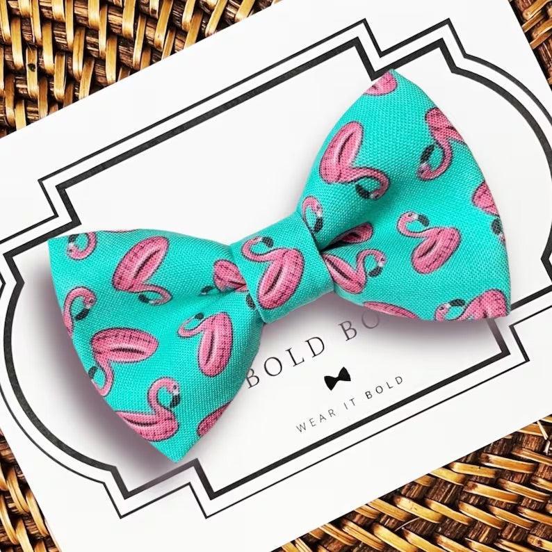 Turquoise flamingo pattern bow tie for dog or cat collar displayed on a white card