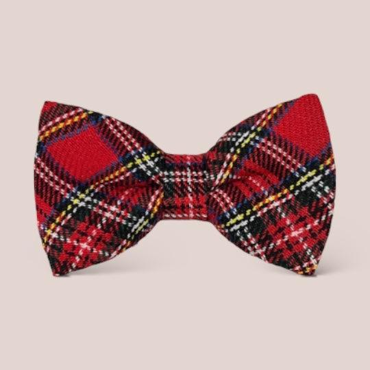 Red tartan plaid hair bow against a light beige background