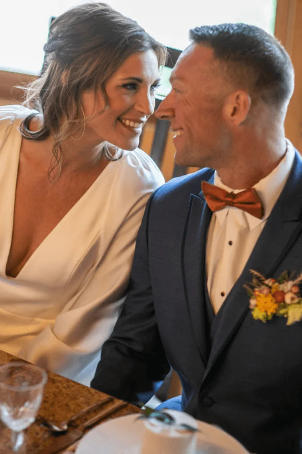 Man in a terracotta bow tie with his bride.