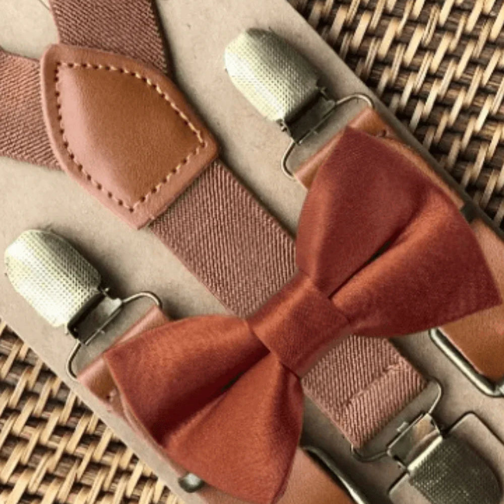 Terracotta bow tie and suspenders on a woven tray with brass clips.