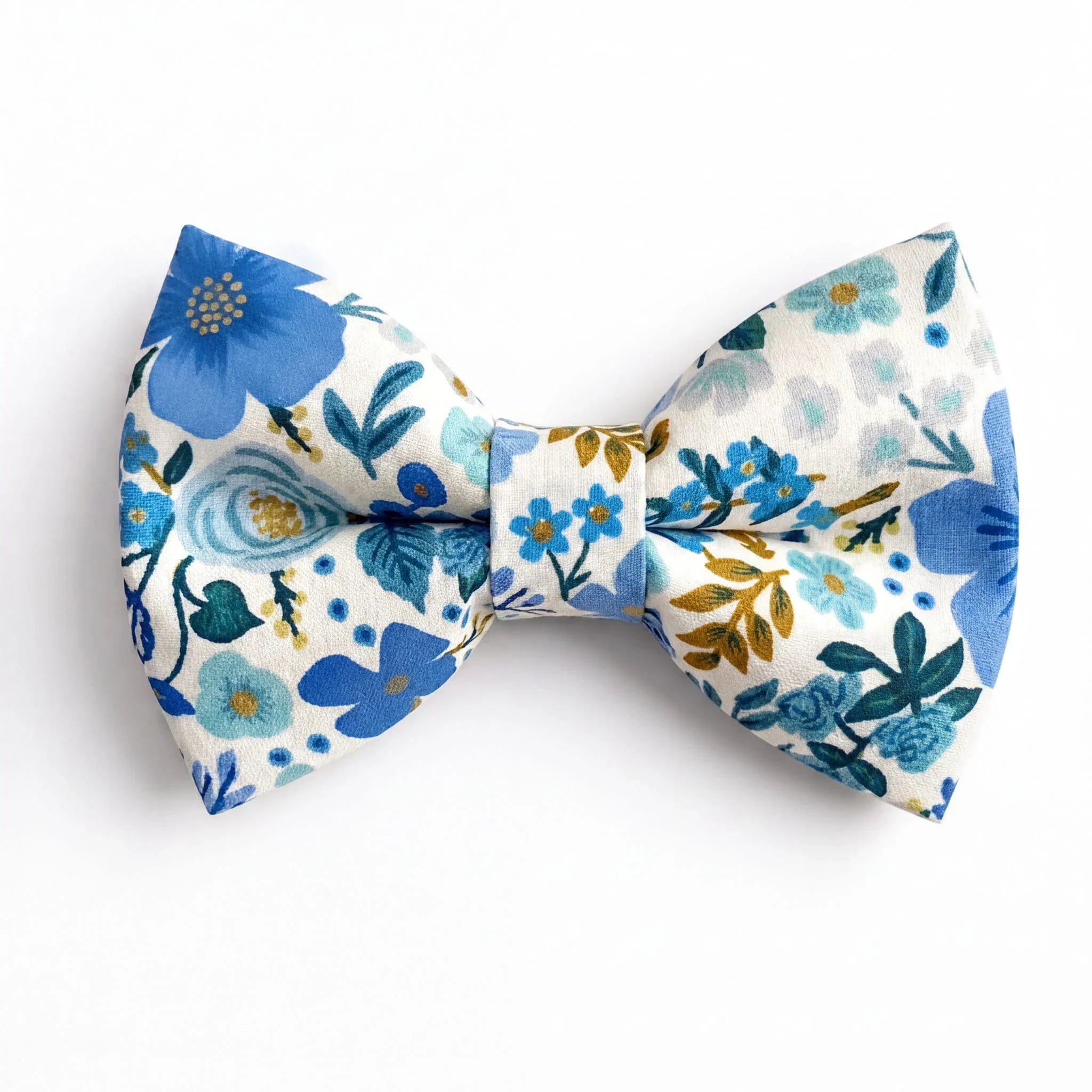 A pre-tied bow tie featuring a cream background with a vibrant pattern of light and dark blue flowers, green foliage, and gold accents.