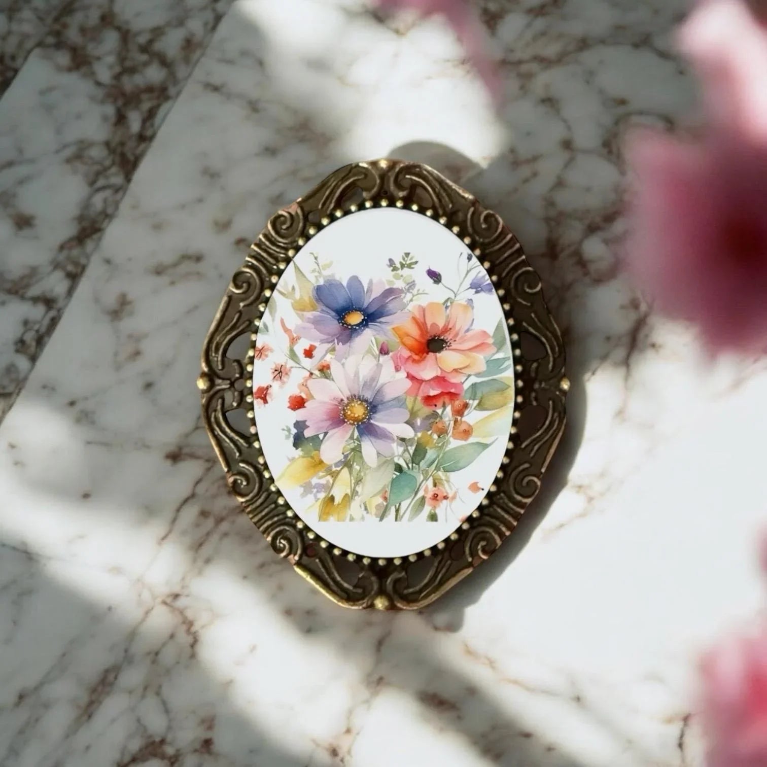 Close-up of a handcrafted oval metal brooch for her showcasing intricate botanical engraving and traditional artisan craftsmanship.