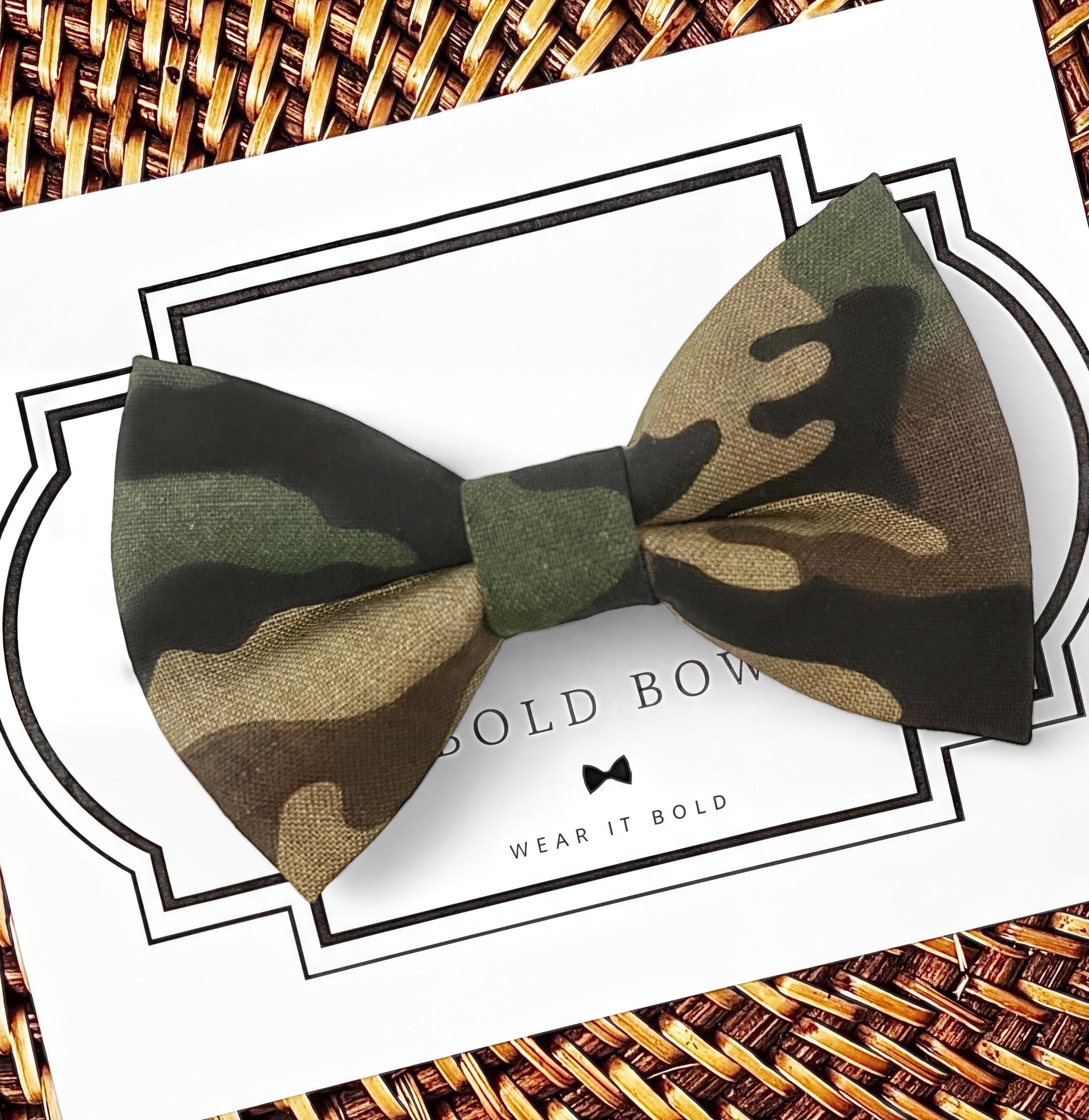 A camouflage bow tie is displayed on a white background with a black border.