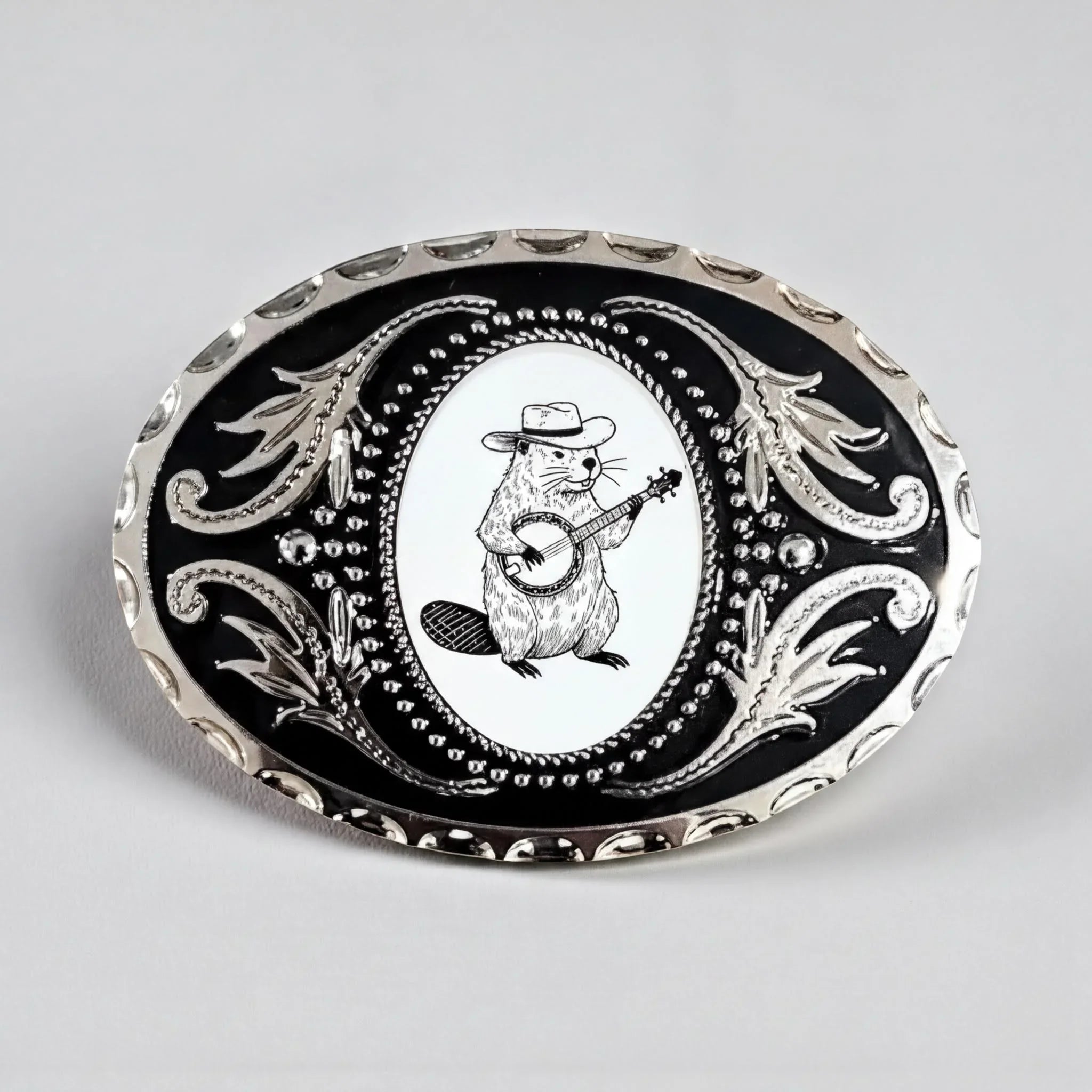 A decorative metal buckle featuring a cartoon image of a beaver playing a banjo.