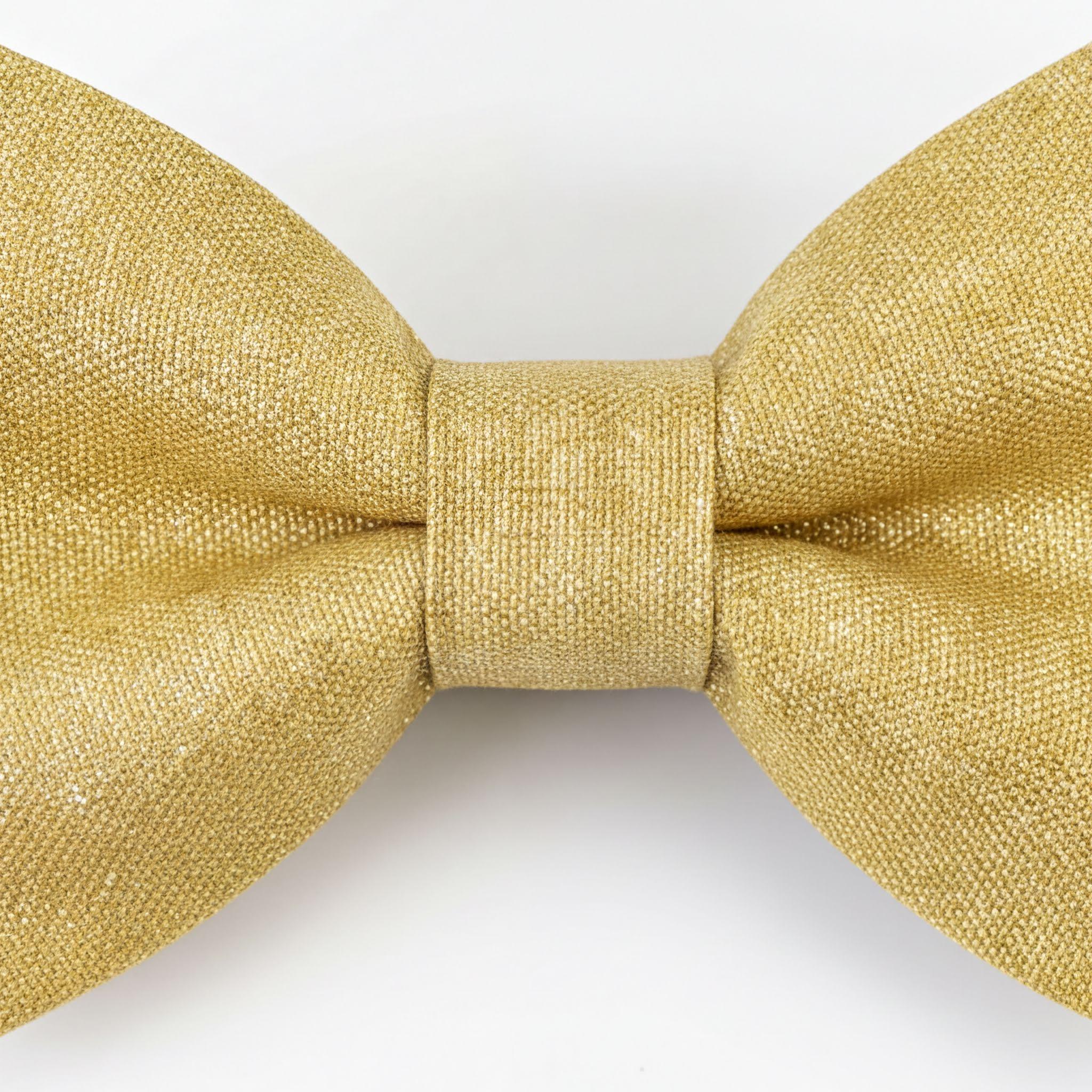 A gold-colored bow tie is shown against a white background.