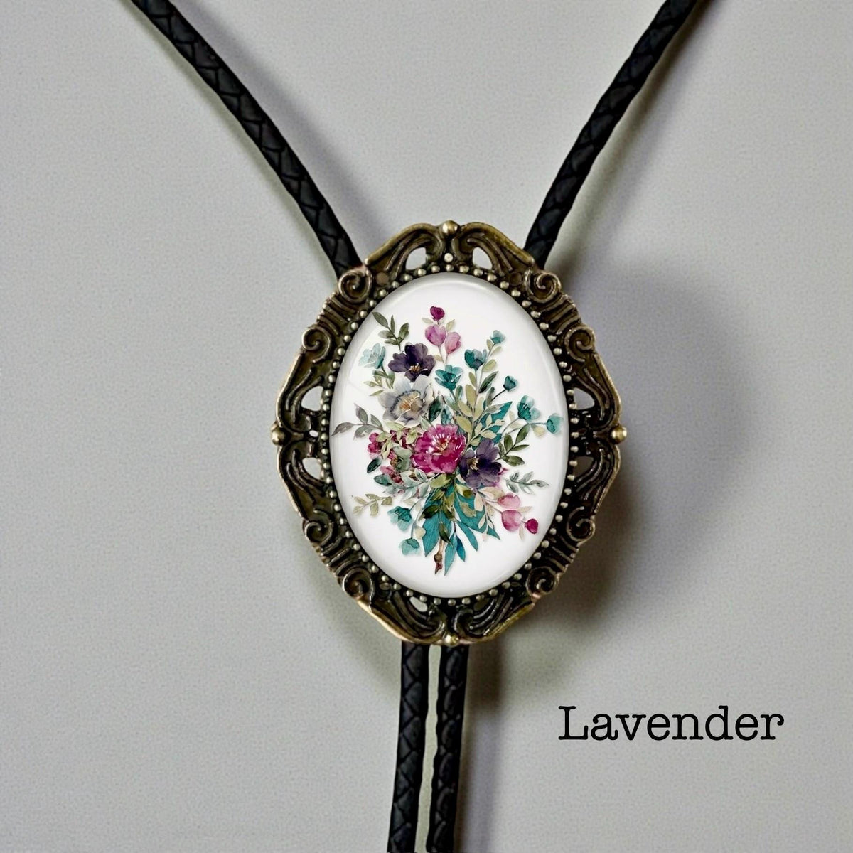 Lavender floral bolo tie with bronze vintage frame and braided leather cord for groom and groomsmen rustic wedding attire.
