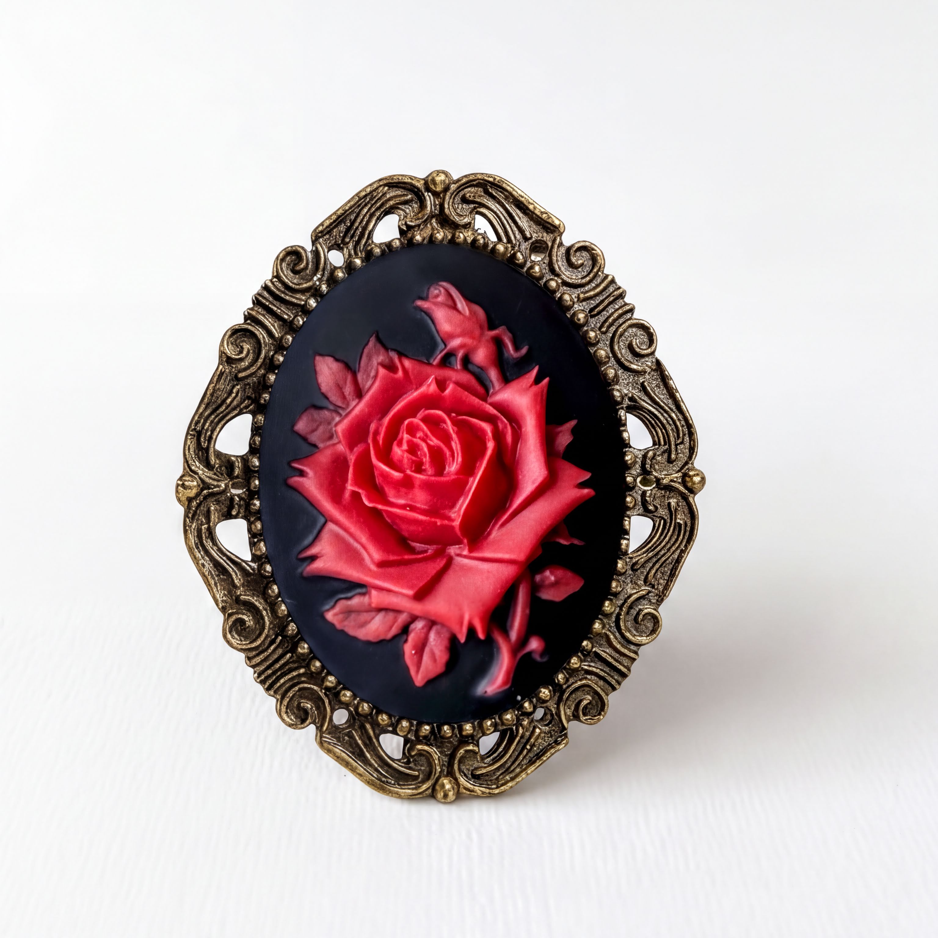 A decorative oval-shaped frame with a red rose painted on it, set against a plain white background.