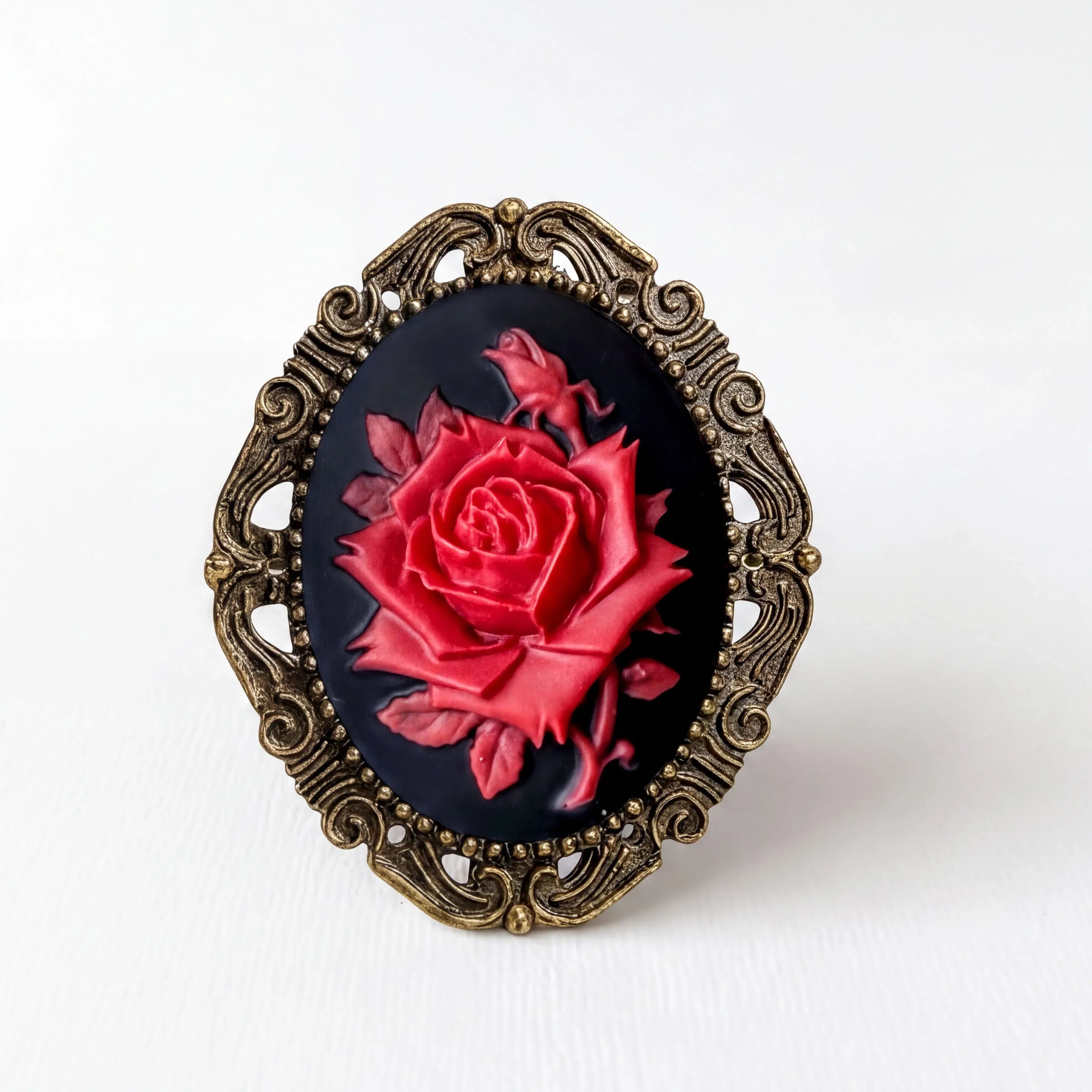 A decorative oval-shaped frame with a red rose painted on it, set against a plain white background.