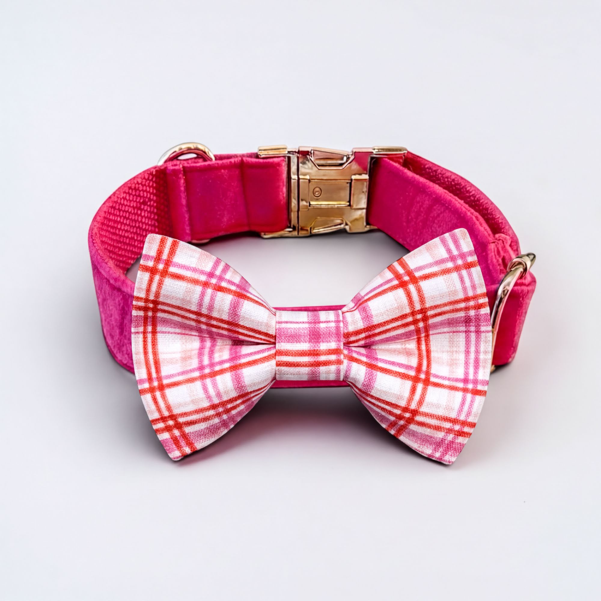 Plaid pink dog collar with a pet bowtie on a light gray background